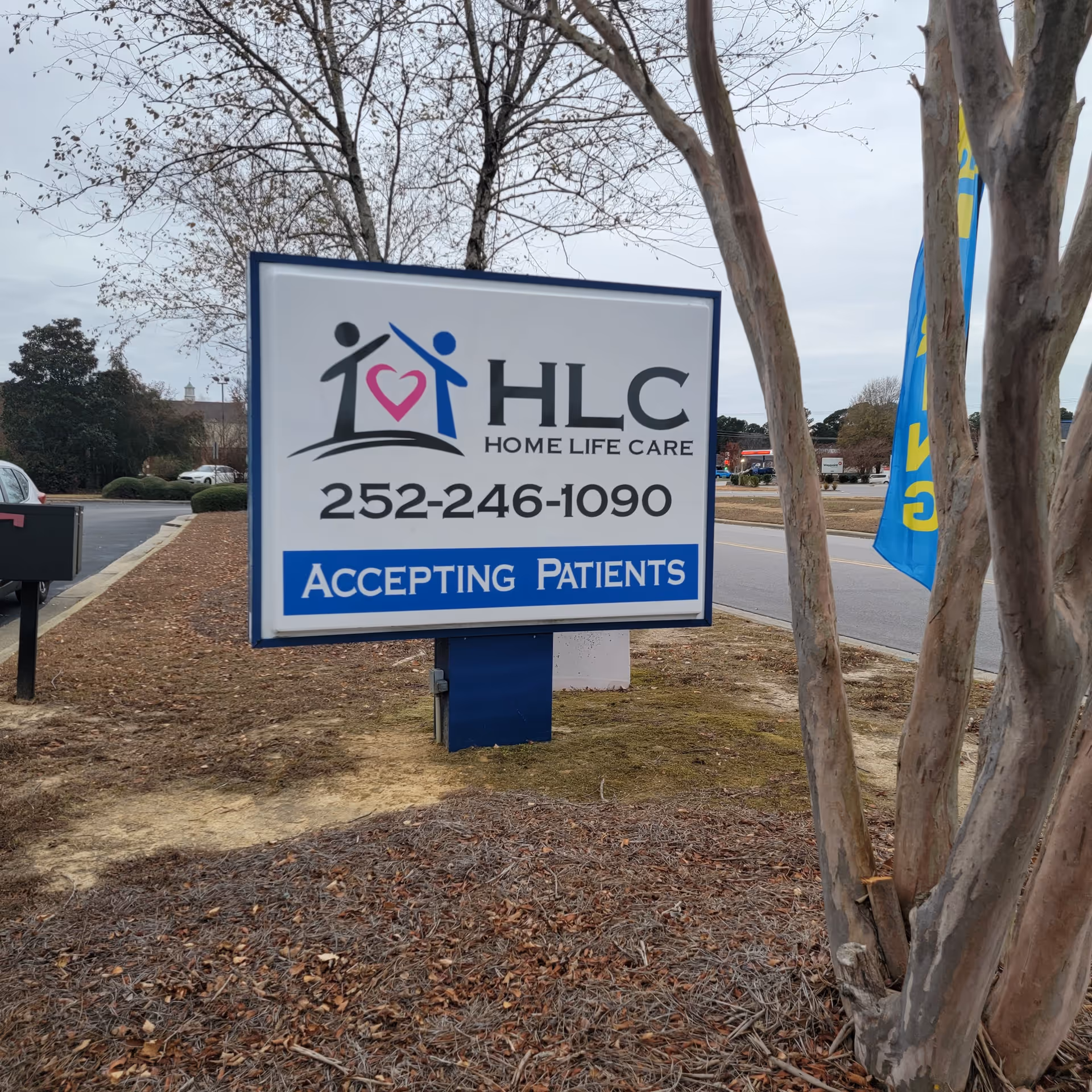 A large roadside sign for Home Life Care with phone number and Accepting Patients.