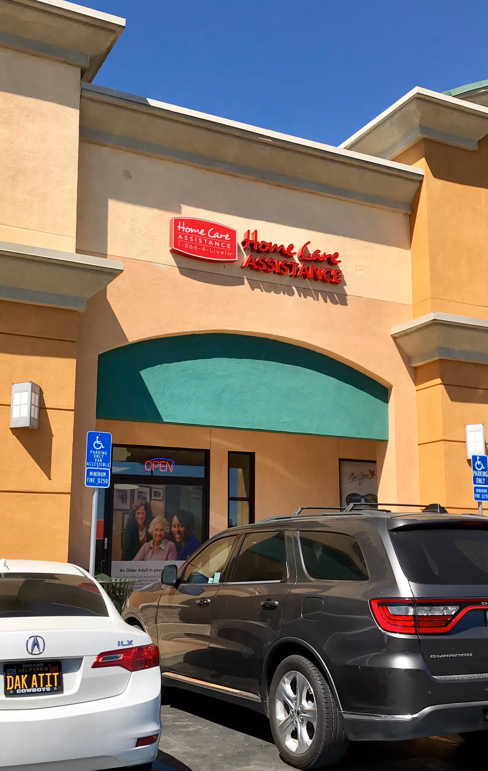 Exterior view of Home Care Assistance building with sign and parked cars