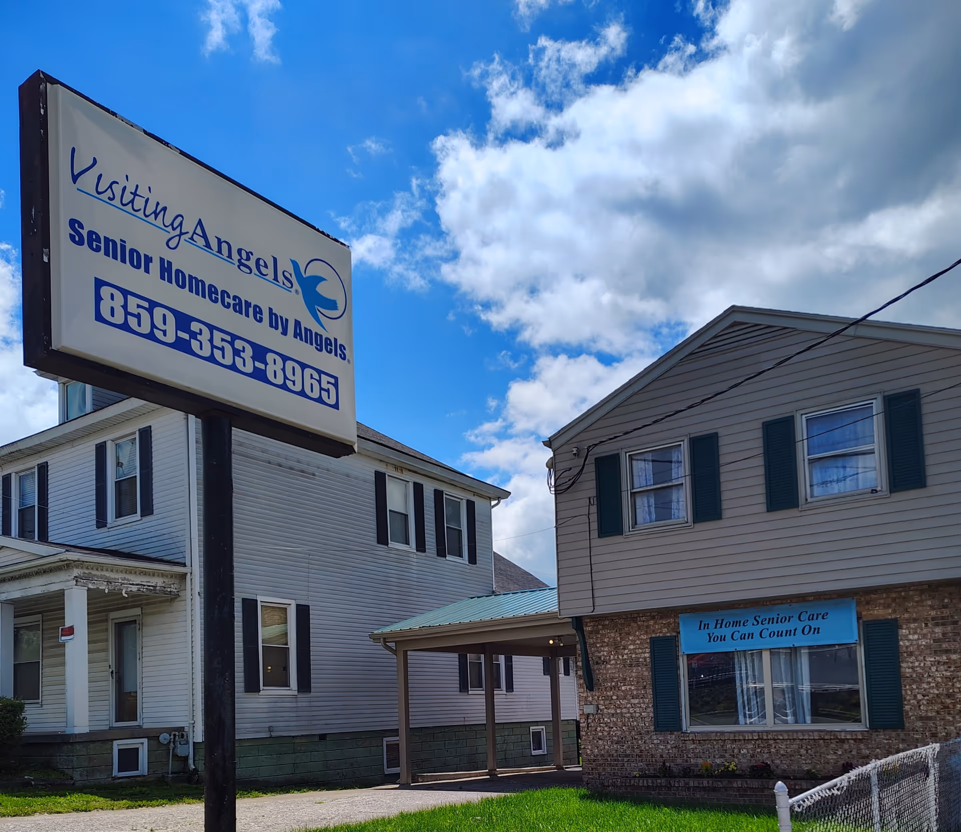 Exterior view of Visiting Angels Senior Home Care building with a large roadside sign.