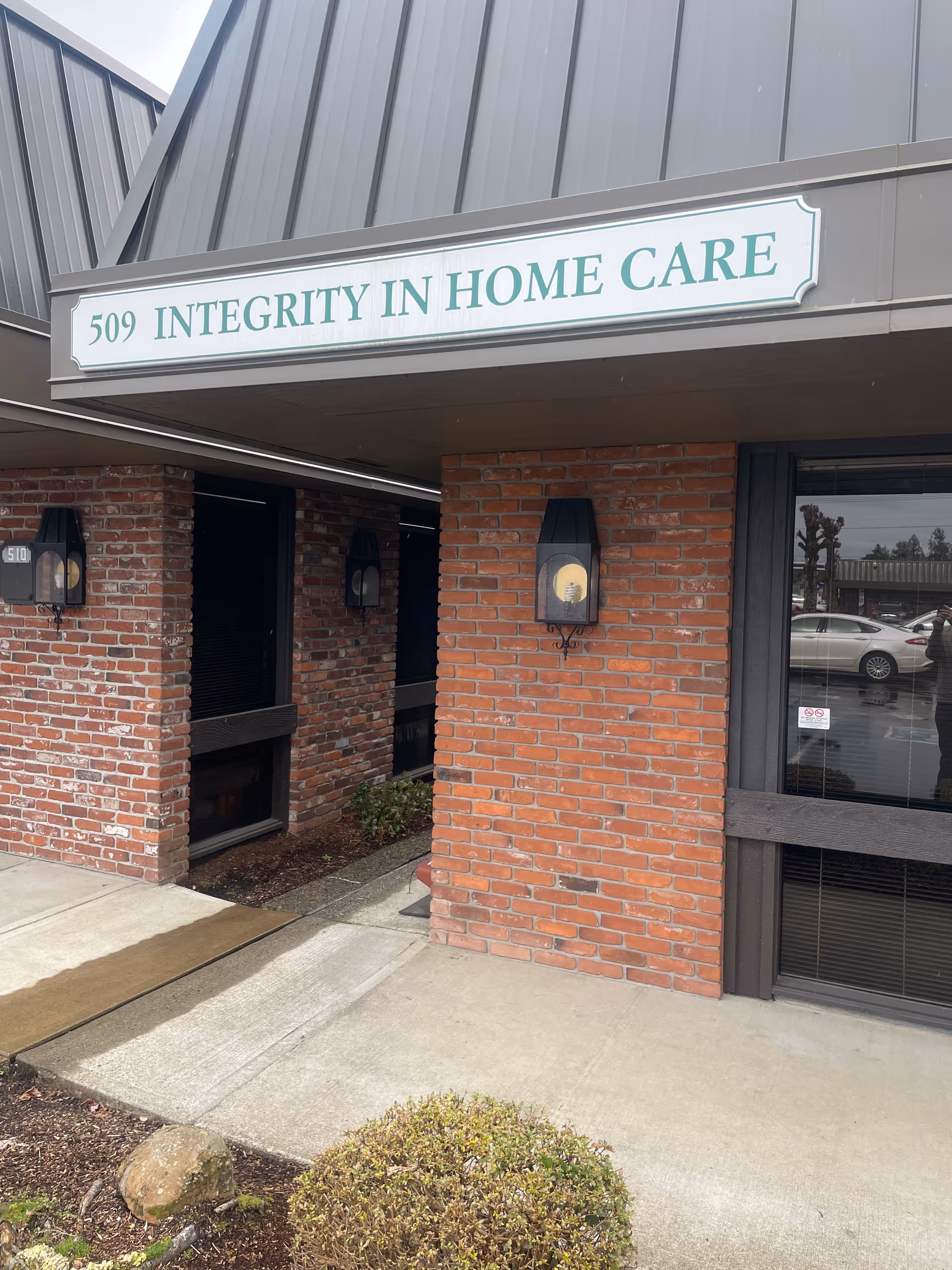 Exterior brick entrance with sign reading Integrity In Home Care Salem.
