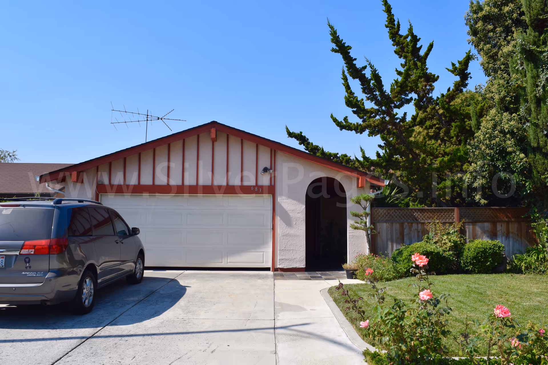 Residential-style single-story house with a two-car garage, driveway, and front yard.