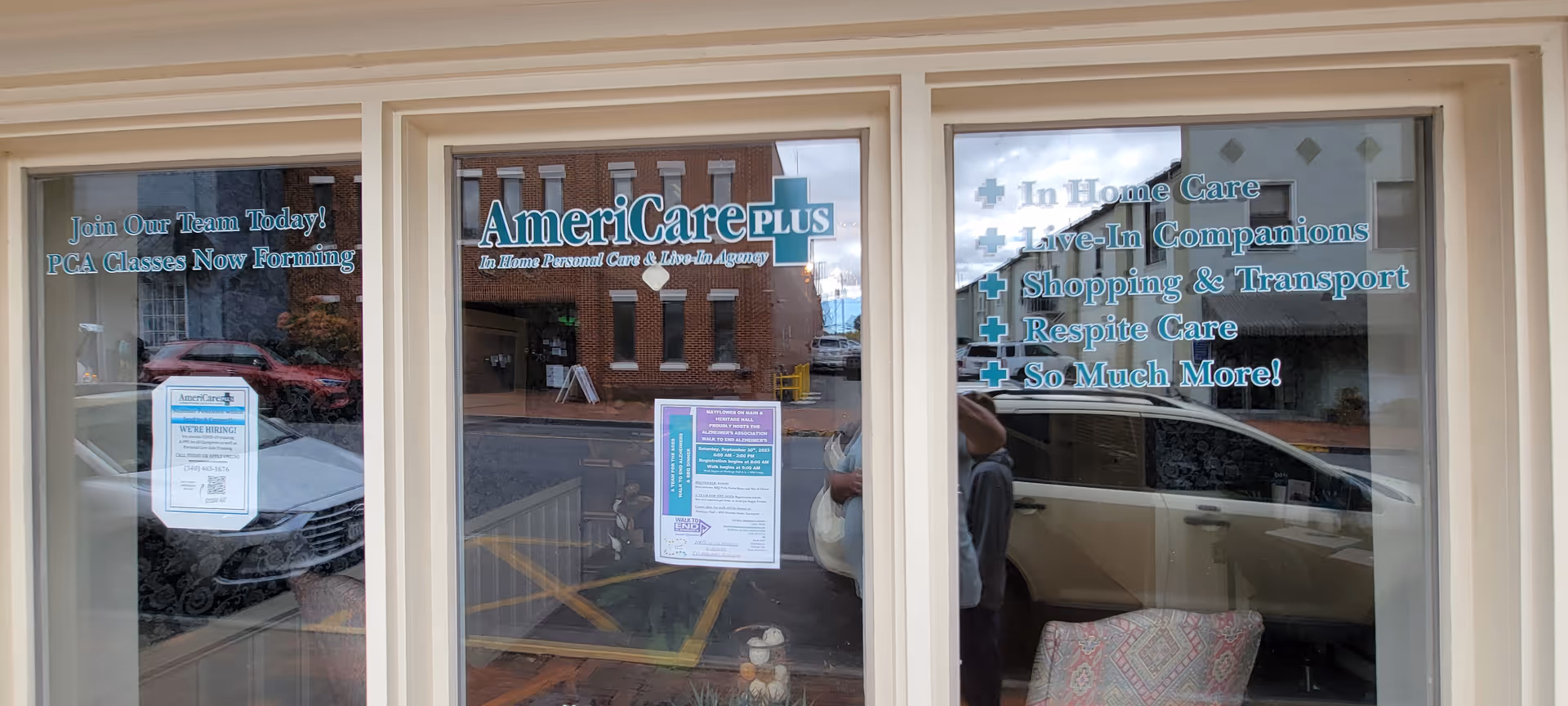 Storefront windows show AmeriCare Plus Home Care Lexington signage and service listings.