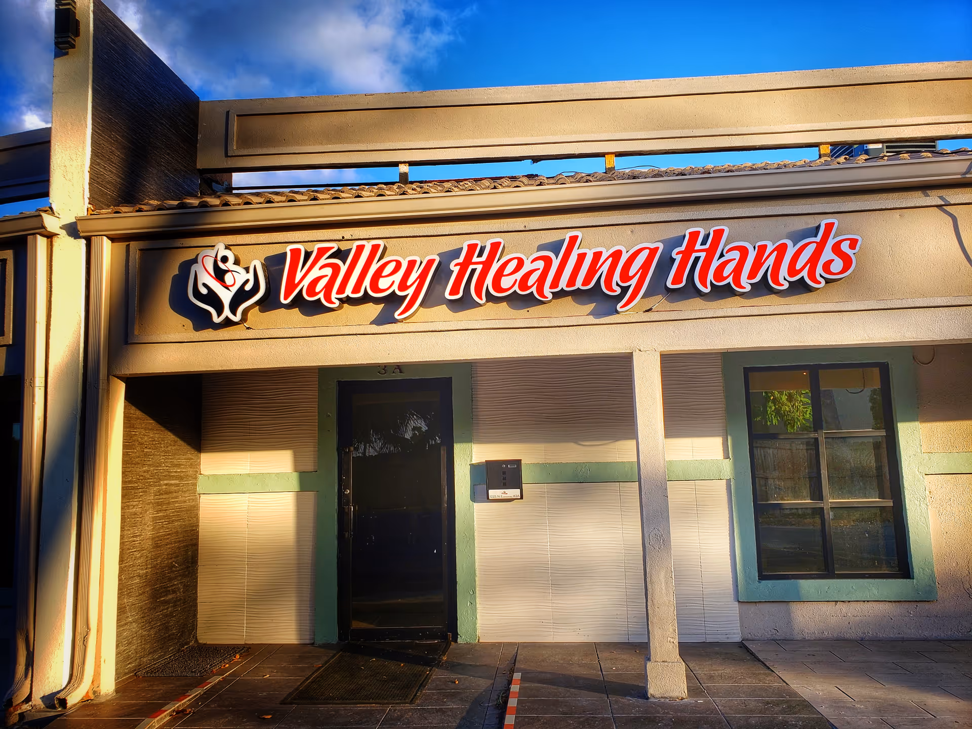 Exterior view of a building with a Valley Healing Hands sign and entrance.