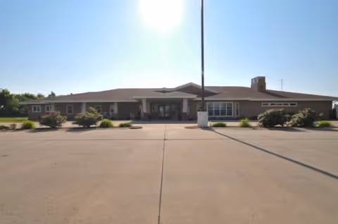 Front exterior view of Windsor Manor senior living facility with entrance and landscaping.