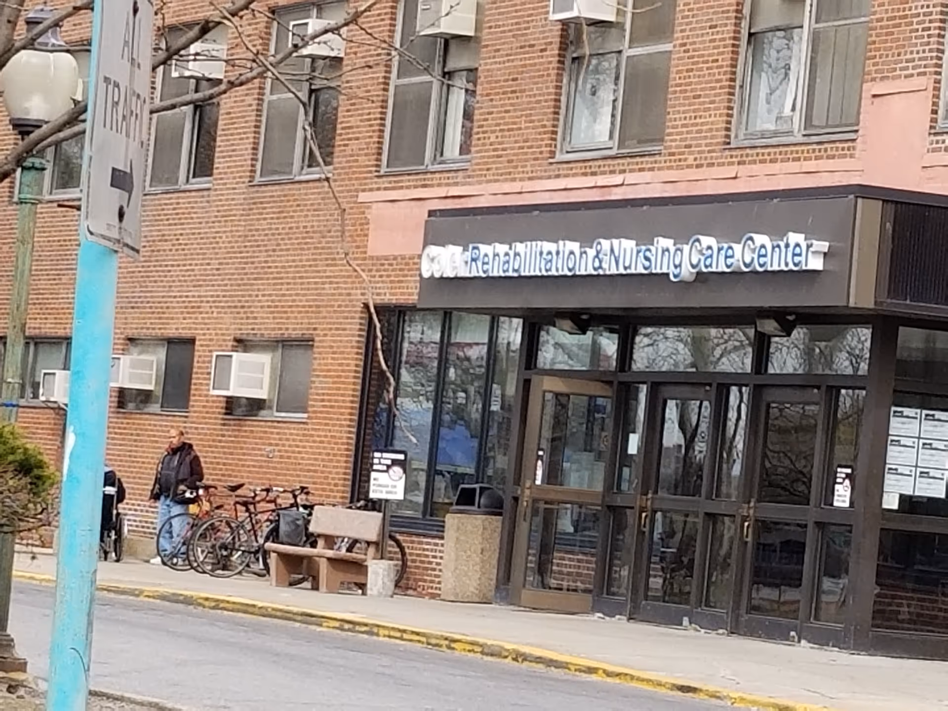 Entrance of Coler Rehabilitation and Nursing Care Center, brick building with bikes outside.