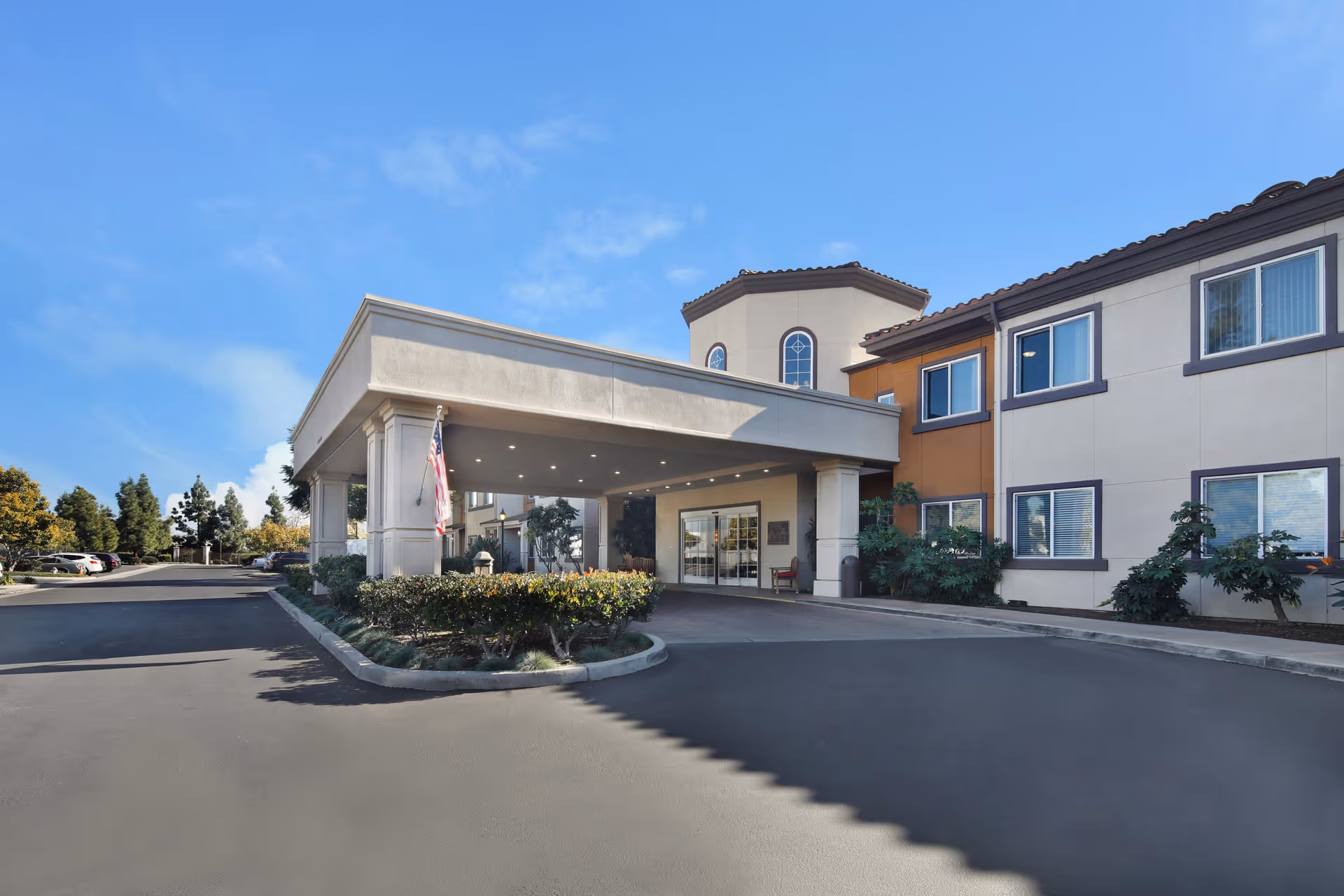 Exterior view of Ivy Park at Cerritos entrance with driveway and landscaping.