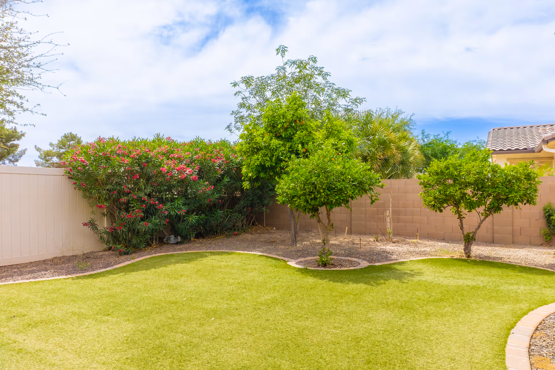 Outdoor yard at Eden Estates Assisted Living with green lawn and trees.