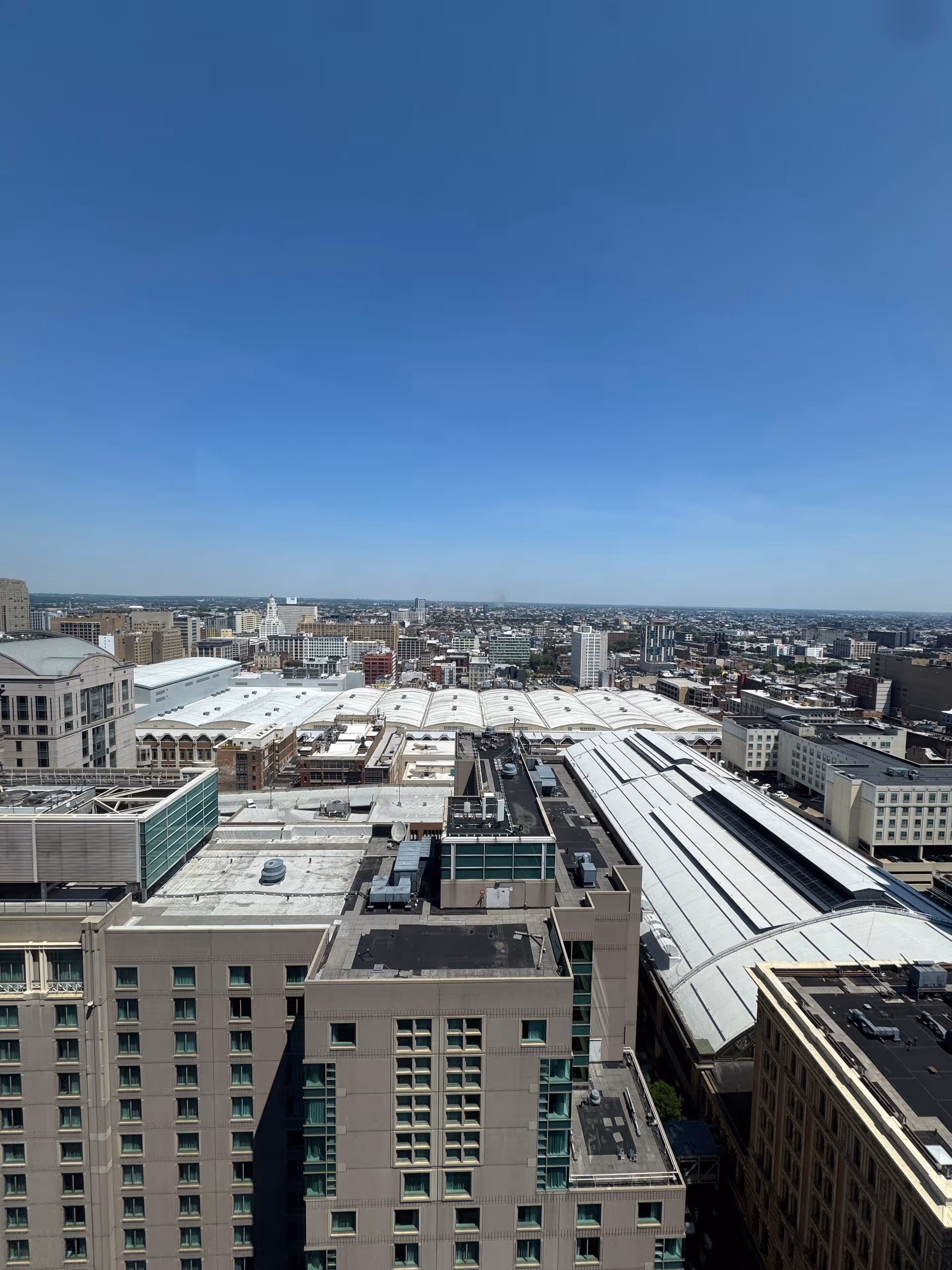 Aerial view of city rooftops under a clear blue sky.