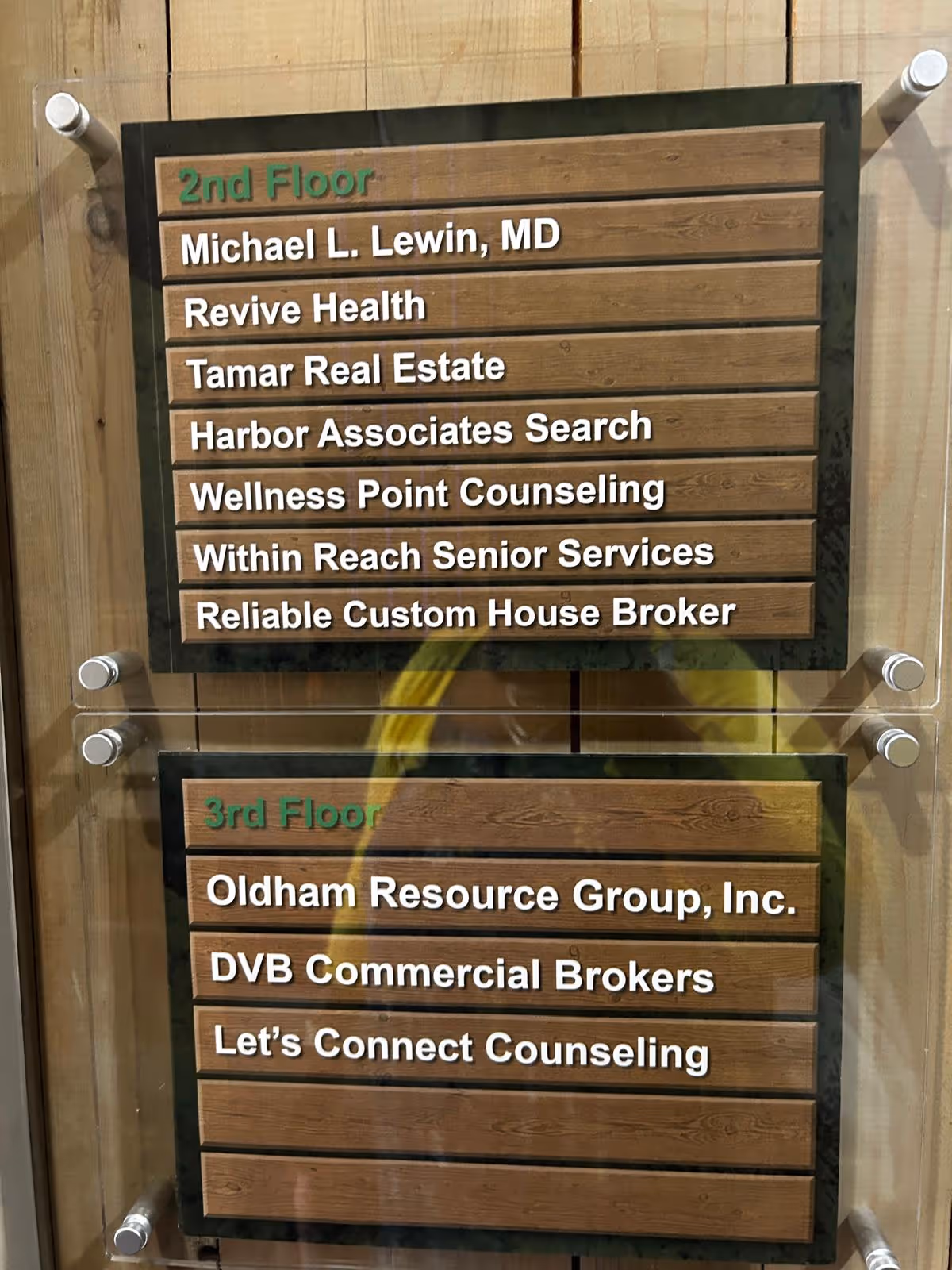 Interior directory board with wooden panels listing offices on the 2nd and 3rd floors.