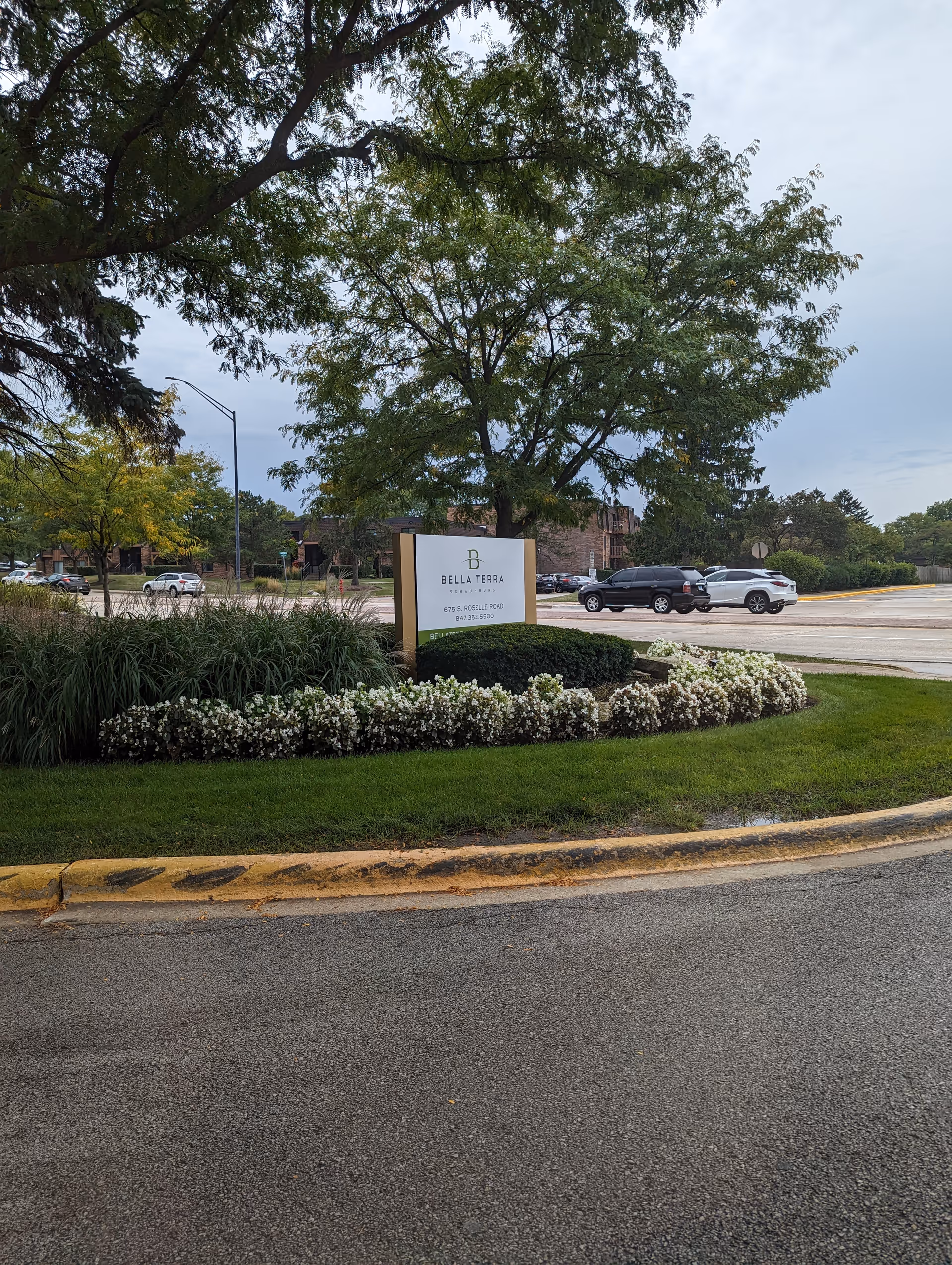 Bella Terra Schaumburg exterior sign with landscaping and parked cars nearby.