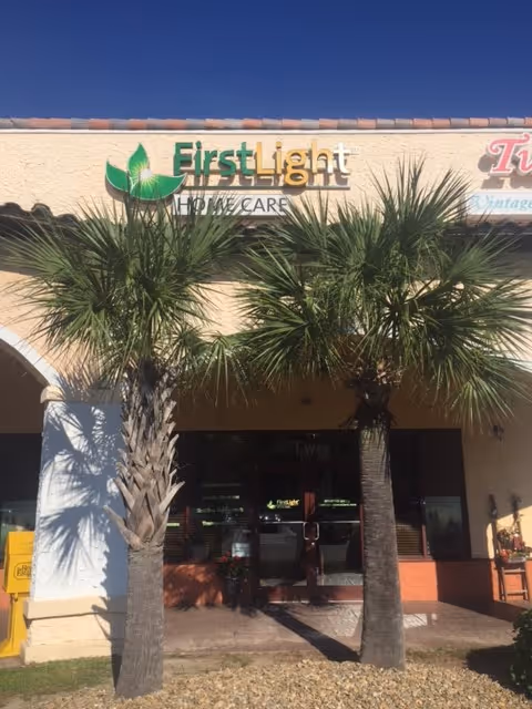 Exterior storefront of FirstLight Home Care with palm trees in front