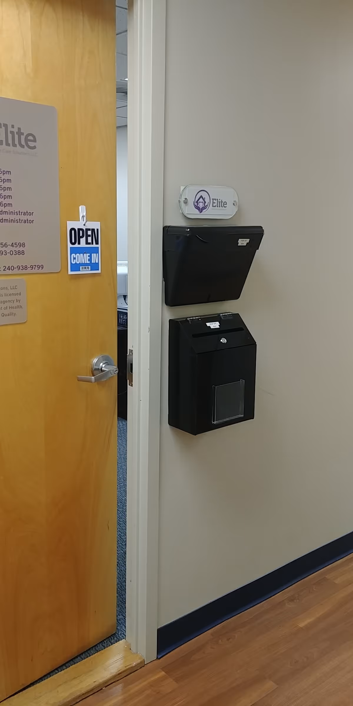 Open doorway to a corridor with an Elite sign and a wall-mounted mailbox.