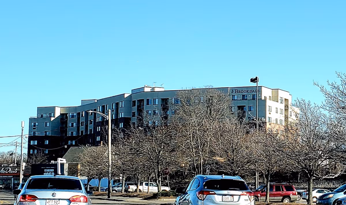 Exterior view of Brookdale Quincy Bay senior living facility with parked cars and leafless trees