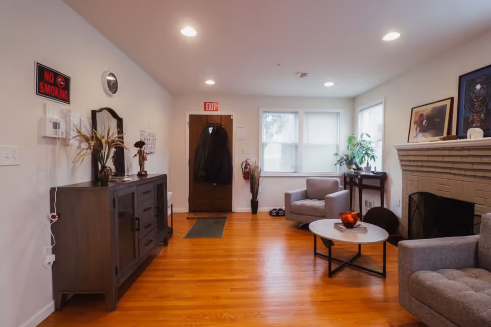 Bright living room with seating, fireplace, coffee table, and decorative artwork.
