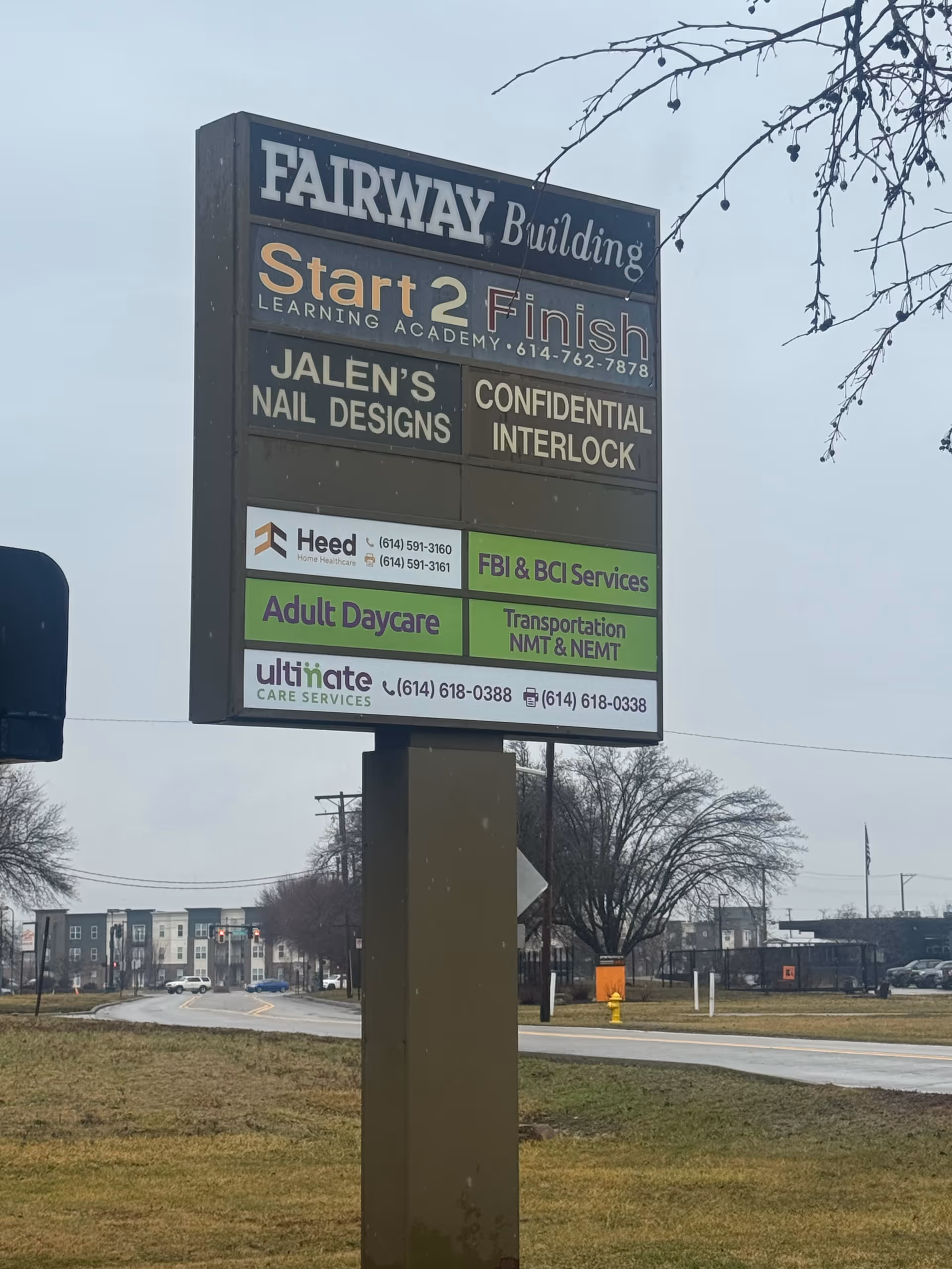 A tall outdoor signboard with multiple business listings, including Ultimate Care Services.