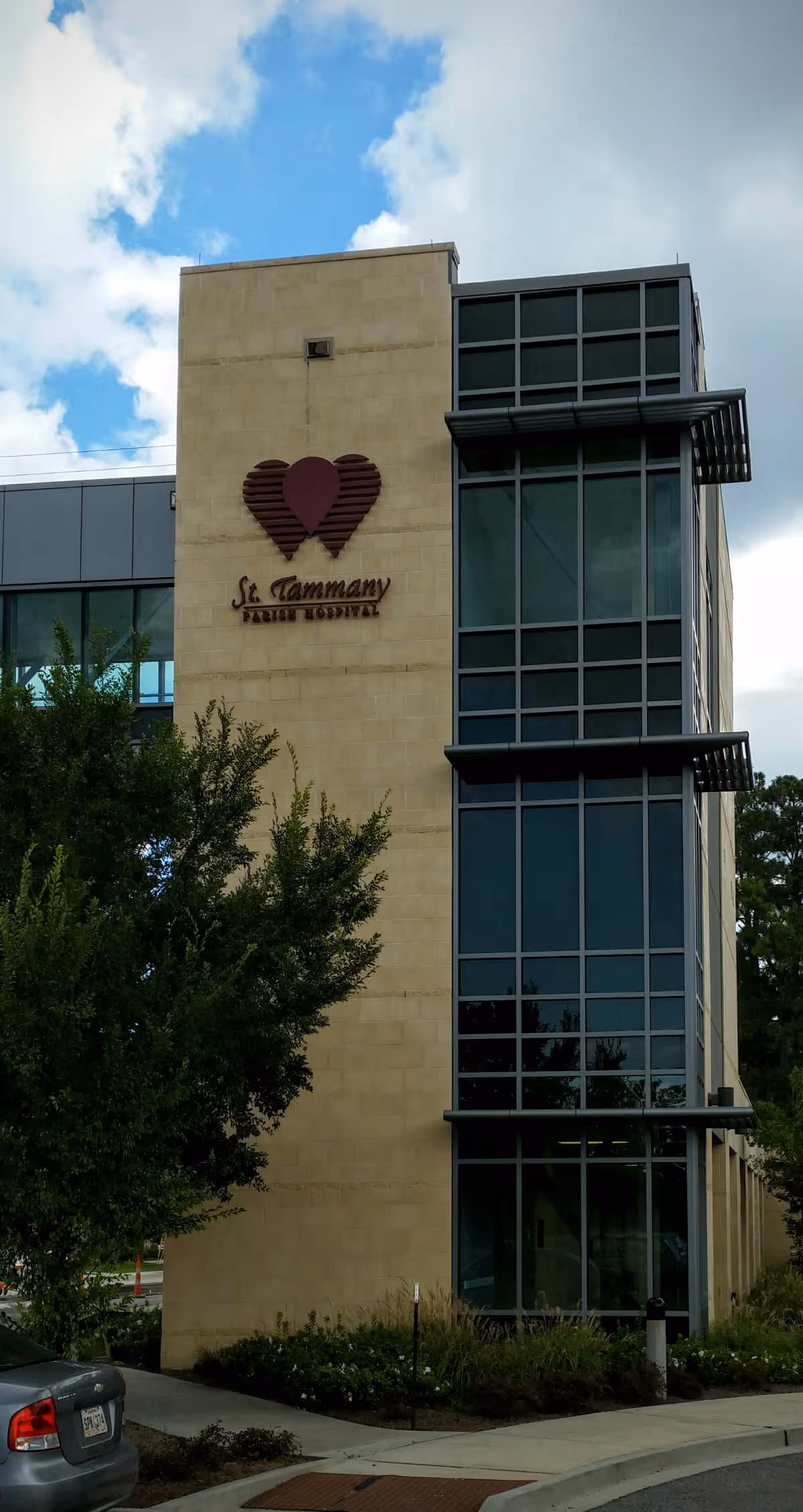 Modern building exterior with glass facade and heart-shaped logo sign.