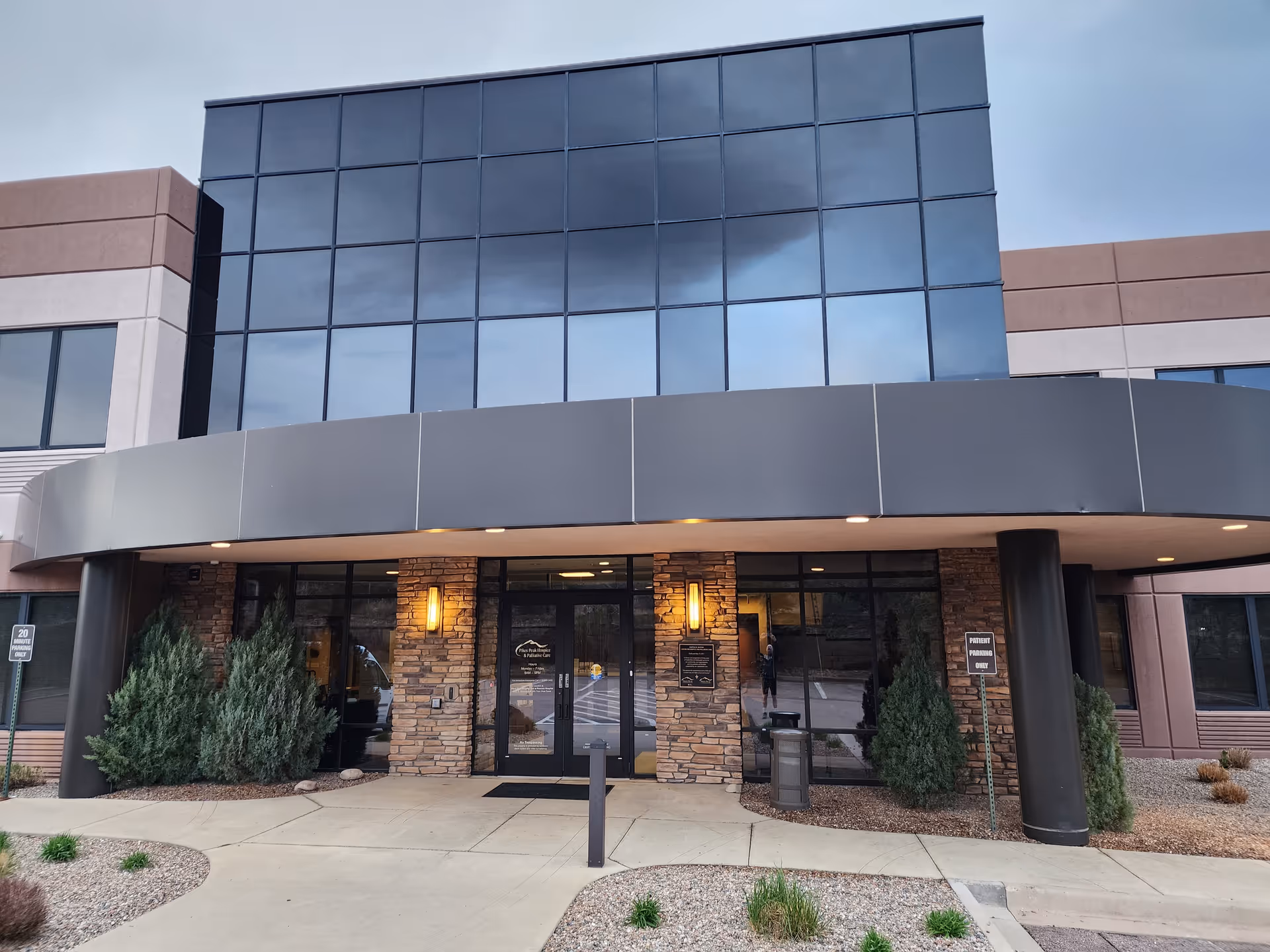 Pikes Peak Hospice & Palliative Care building exterior with glass facade and curved entrance canopy.