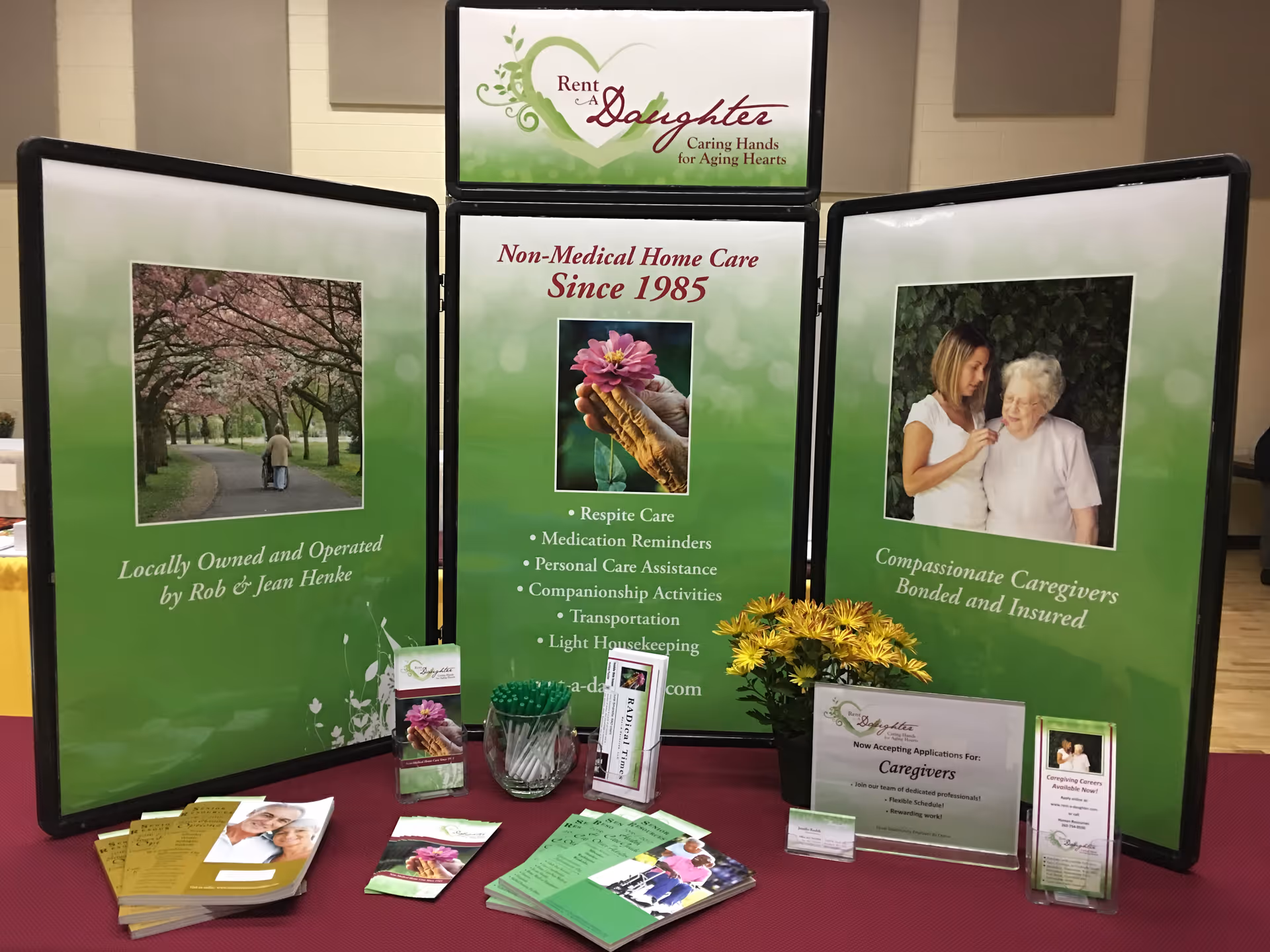 Three-panel promotional display for Rent-A-Daughter home care with brochures.