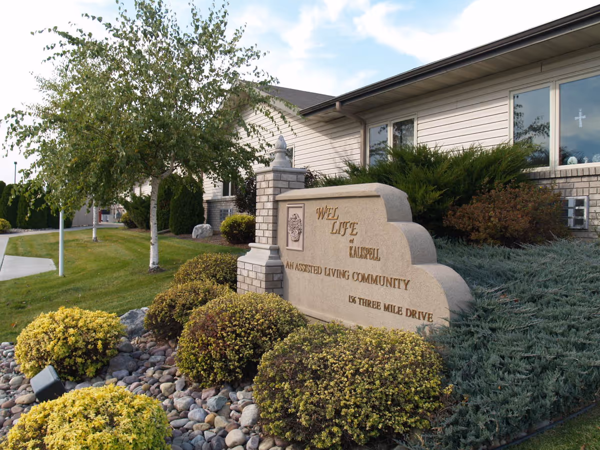 Exterior view of Wel-Life at Kalispell with landscaped entrance sign.