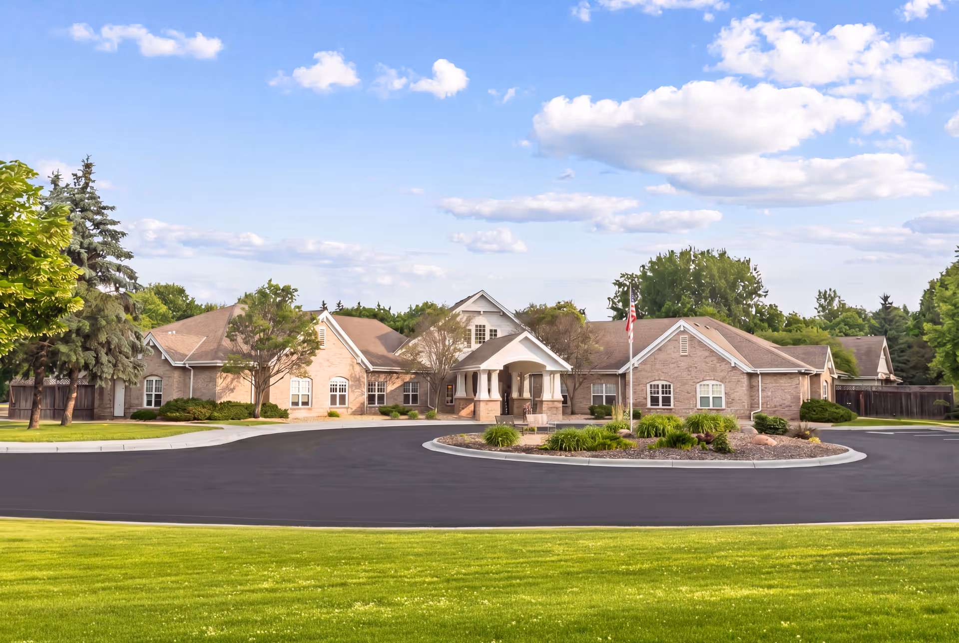 Front view of Brookdale North Oaks senior living facility with a circular driveway and landscaped entrance.