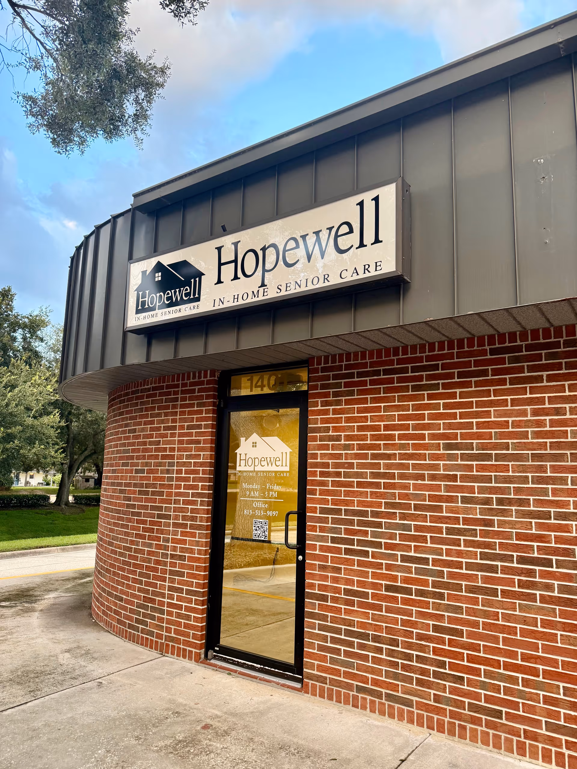 Exterior brick building with Hopewell sign and glass entrance door.