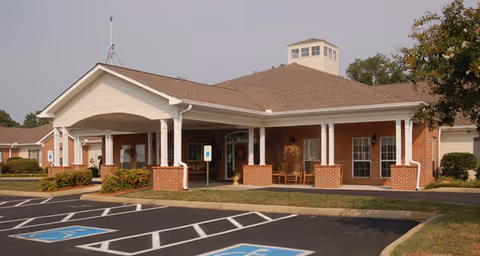 Brookdale Browns Creek exterior featuring a covered entrance and parking spaces.