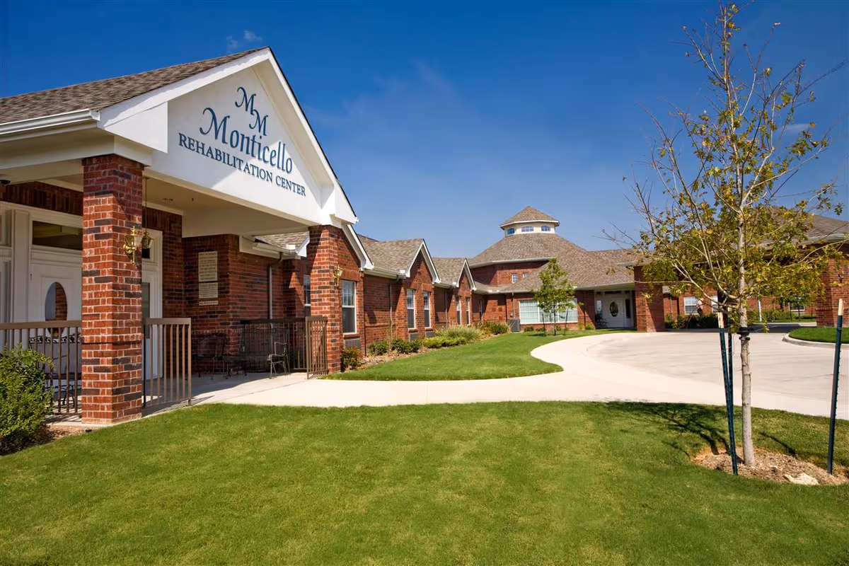 Brick senior living facility with curved driveway, manicured lawn, and welcoming entrance.