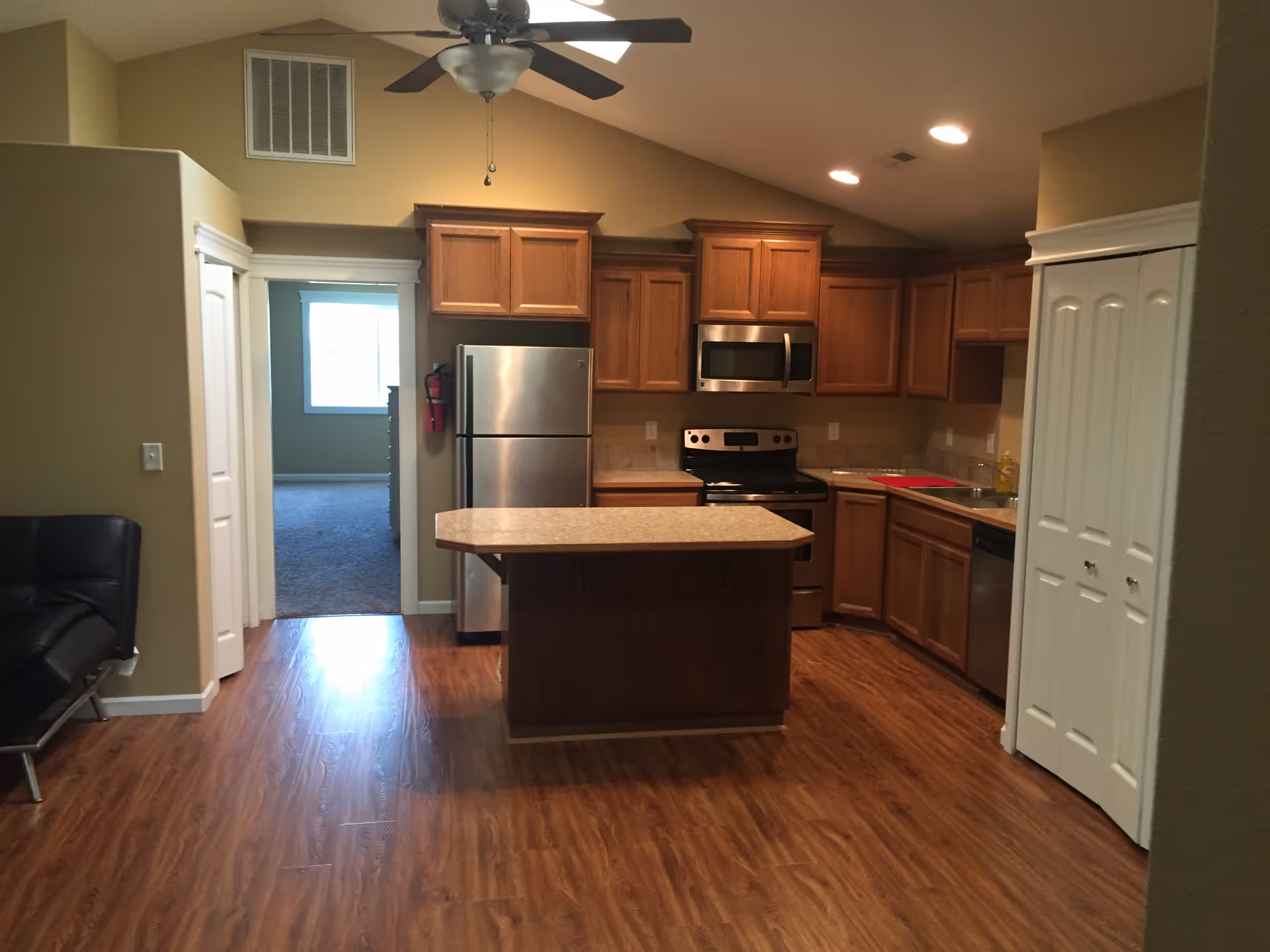 Modern kitchen with wooden cabinets, stainless steel appliances, and an island in a senior living home.