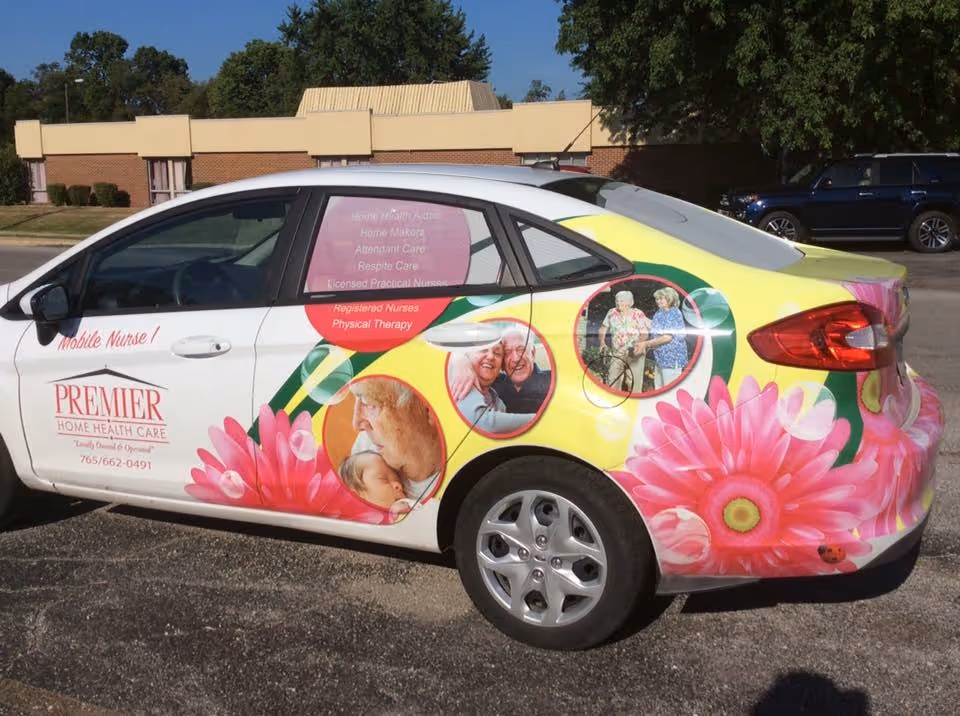 Colorful Premier Home Health Care branded car parked in a lot with a building in background