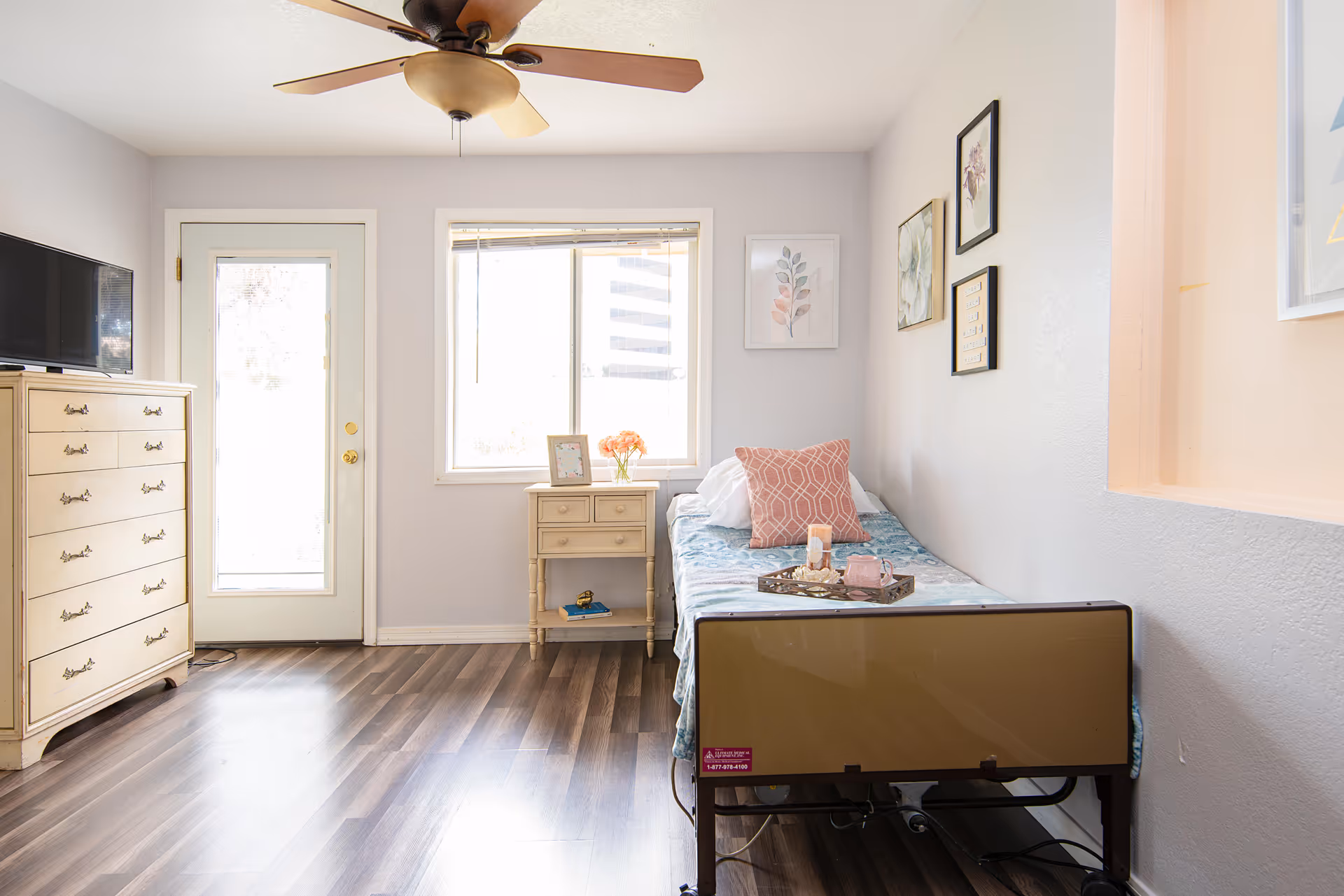 Bright bedroom with a single bed, dresser, nightstand, window, and ceiling fan.