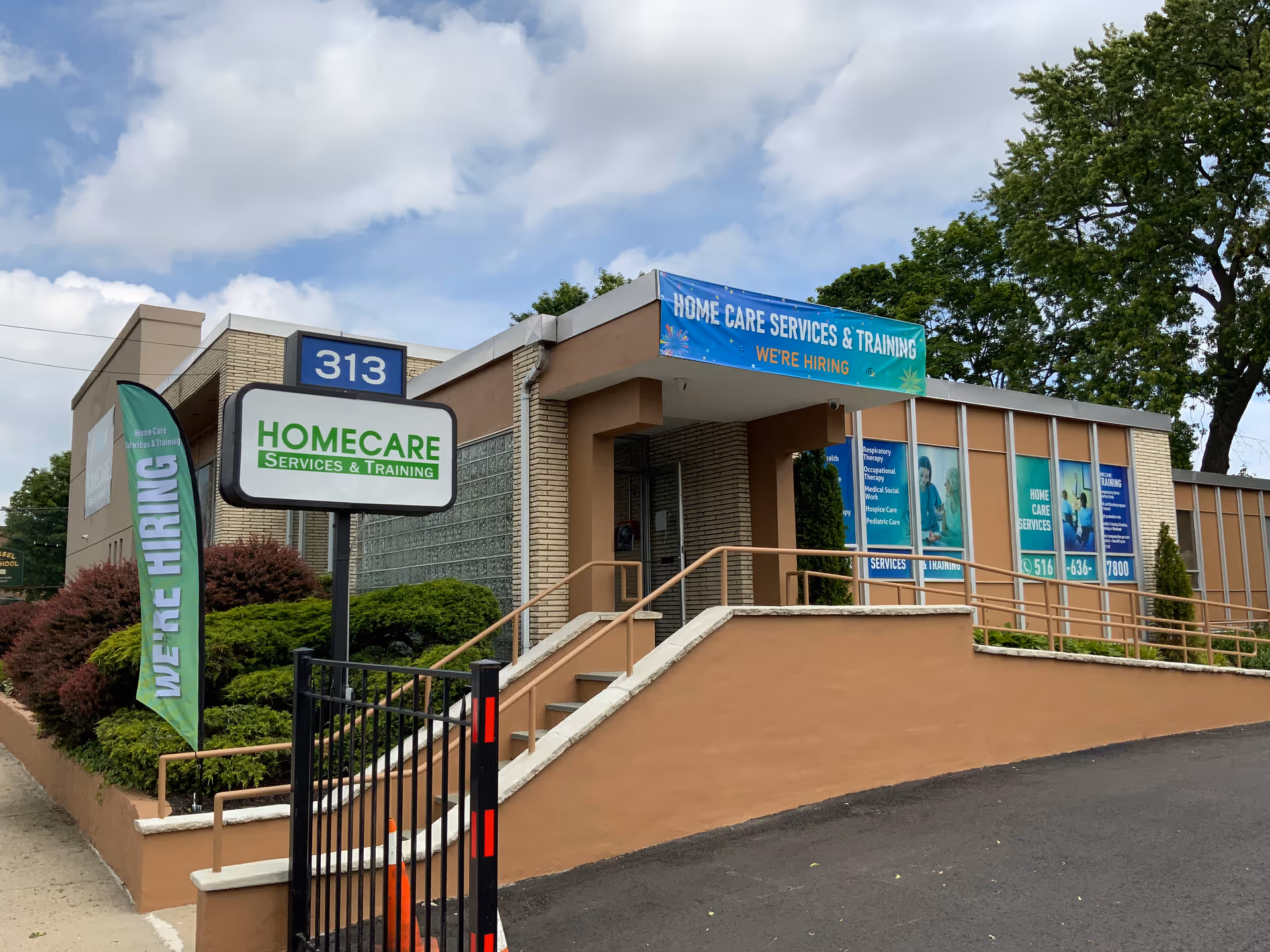 Exterior view of ABI Health Care building with ramp, banners, and parking.