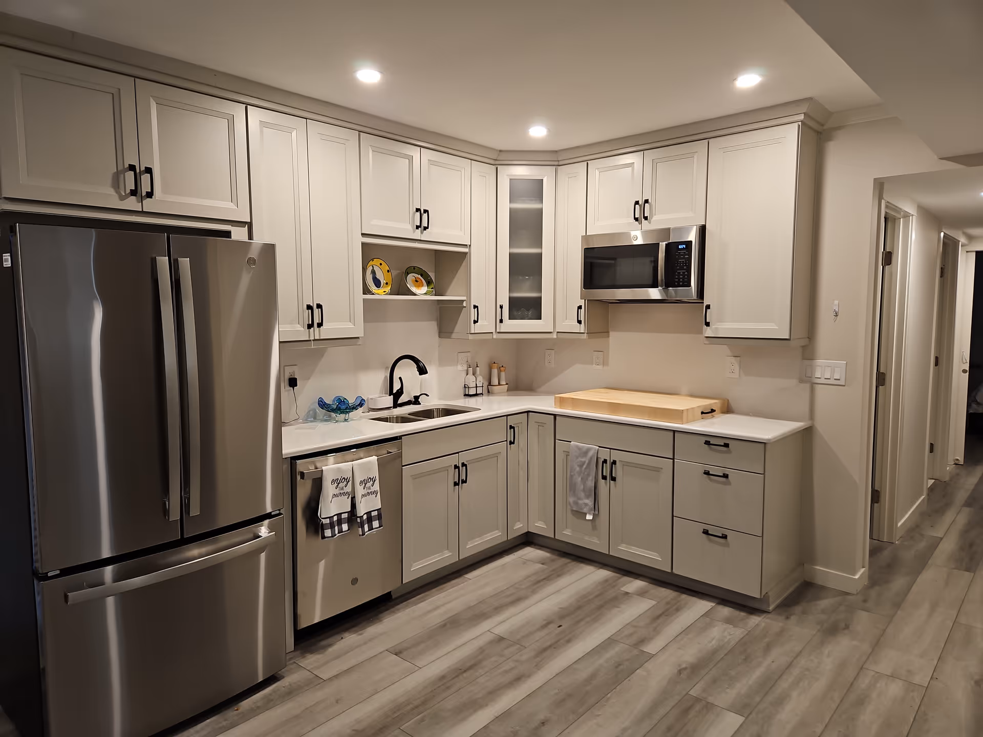 Modern kitchen in a senior living facility with white cabinets and stainless appliances.