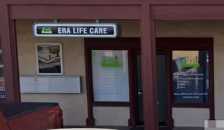 Exterior view of Era Life Care facility entrance with signs and posters.