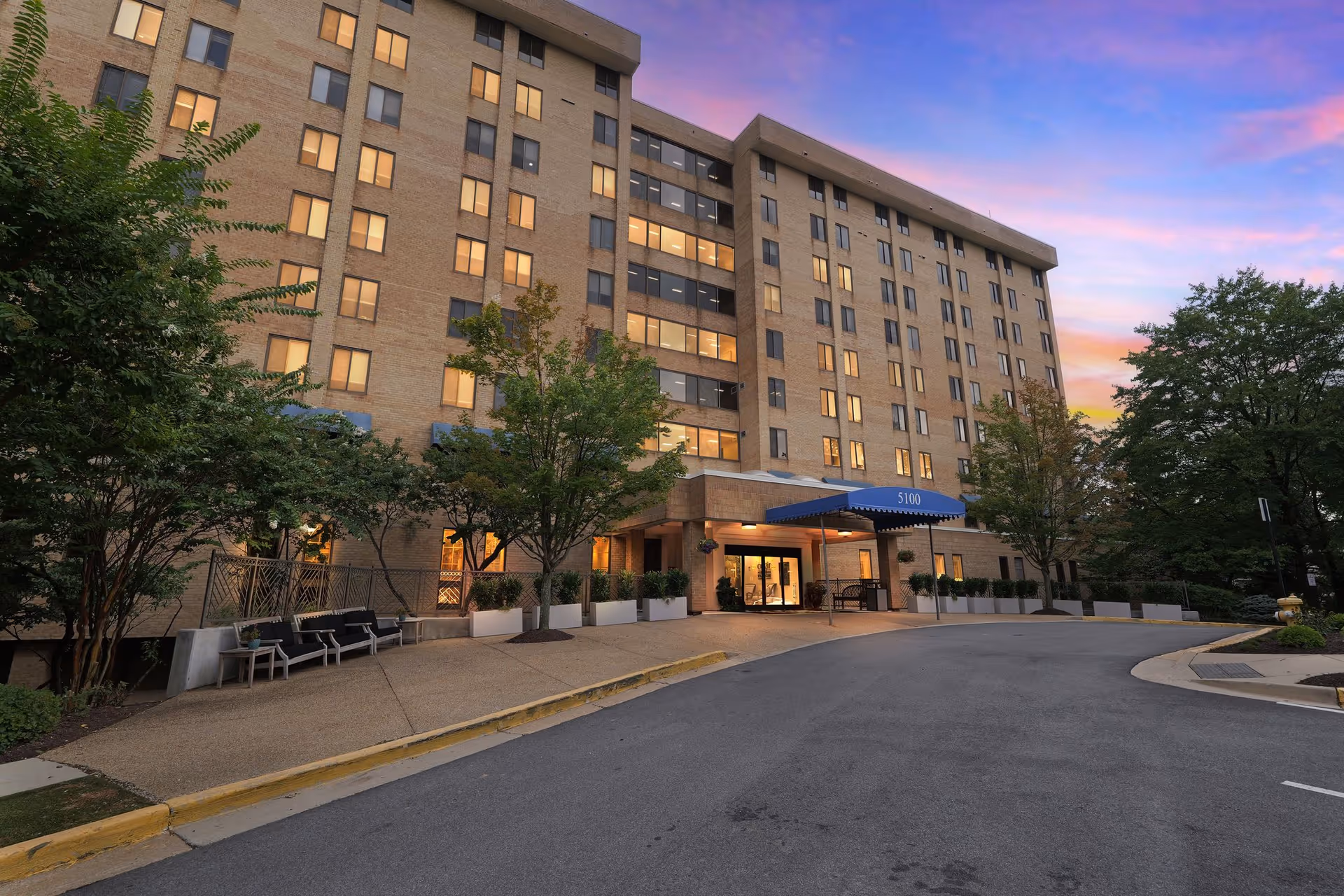 Exterior view of Elancé at Alexandria by Cogir, a brick senior living building with entrance.