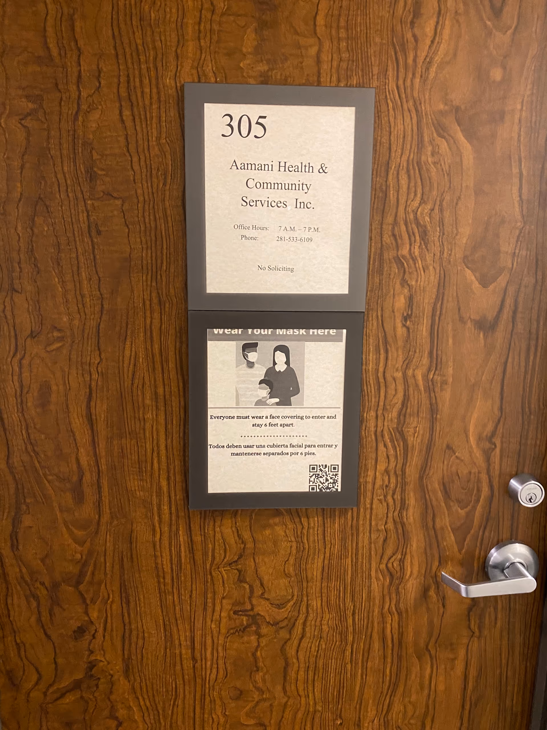 Wooden door with two framed signs: unit 305 and mask-wearing notice.