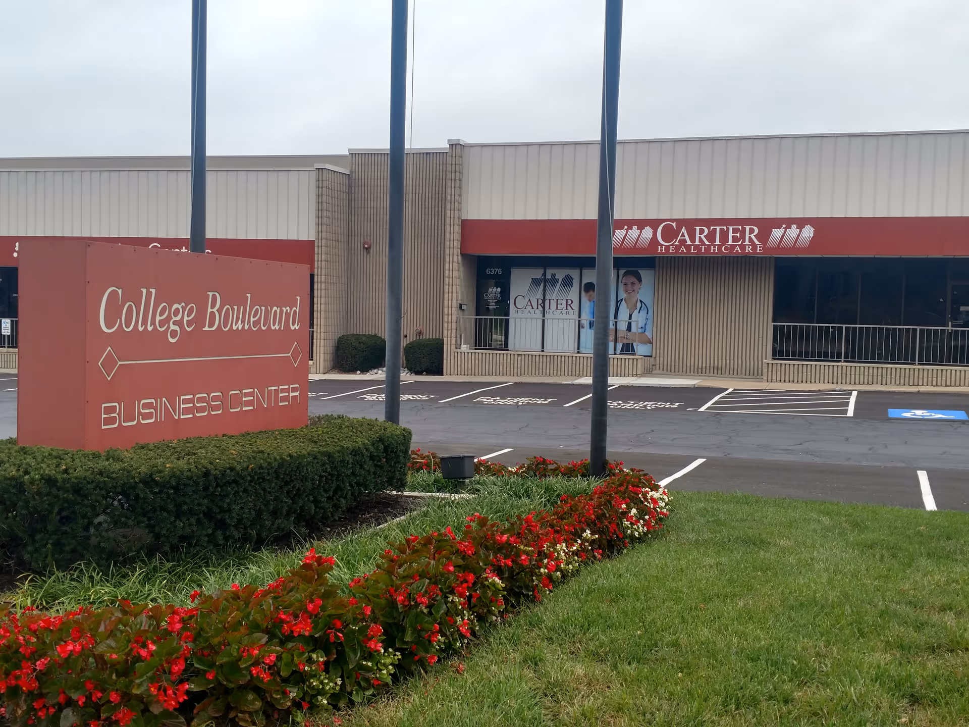 Exterior view of Carter Healthcare building with College Boulevard Business Center sign and parking.
