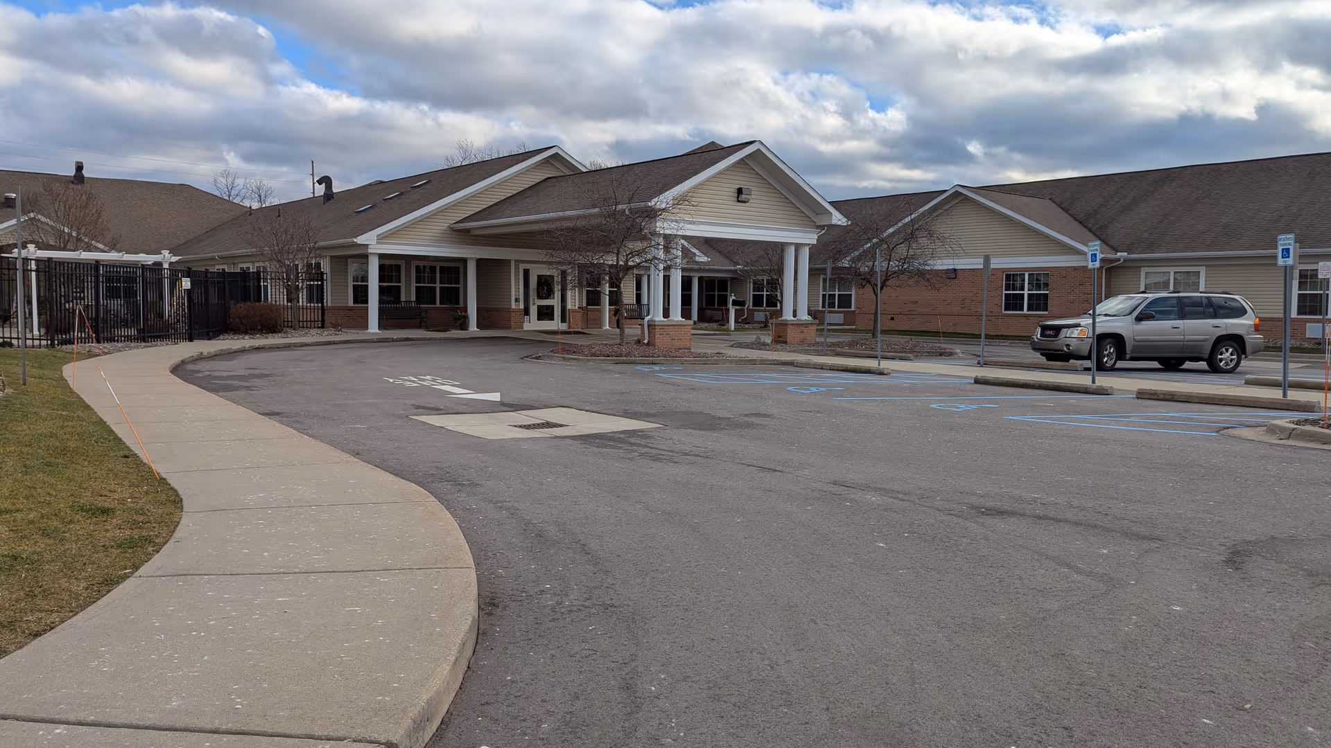 Exterior view of Stonegate Health Campus with entrance, curved walkway, and parking.