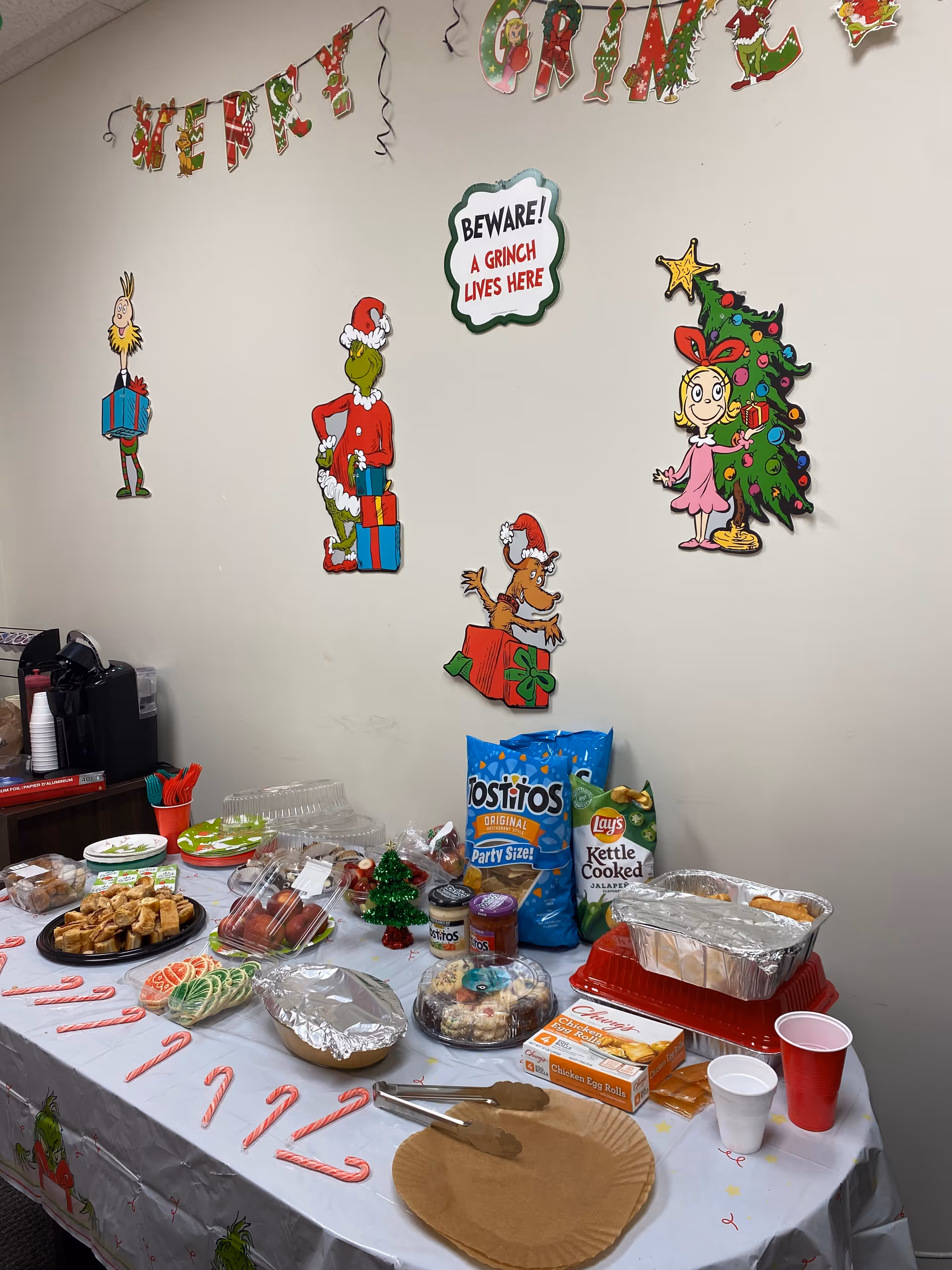 Indoor room with a decorated holiday food table and festive wall decals.