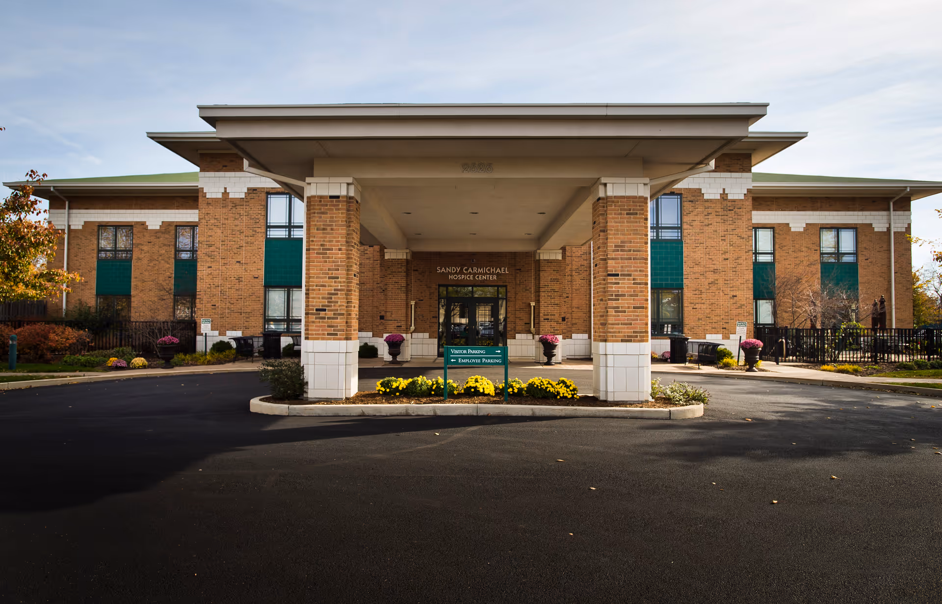 Brick hospice facility with a wide covered entrance and circular driveway in front.