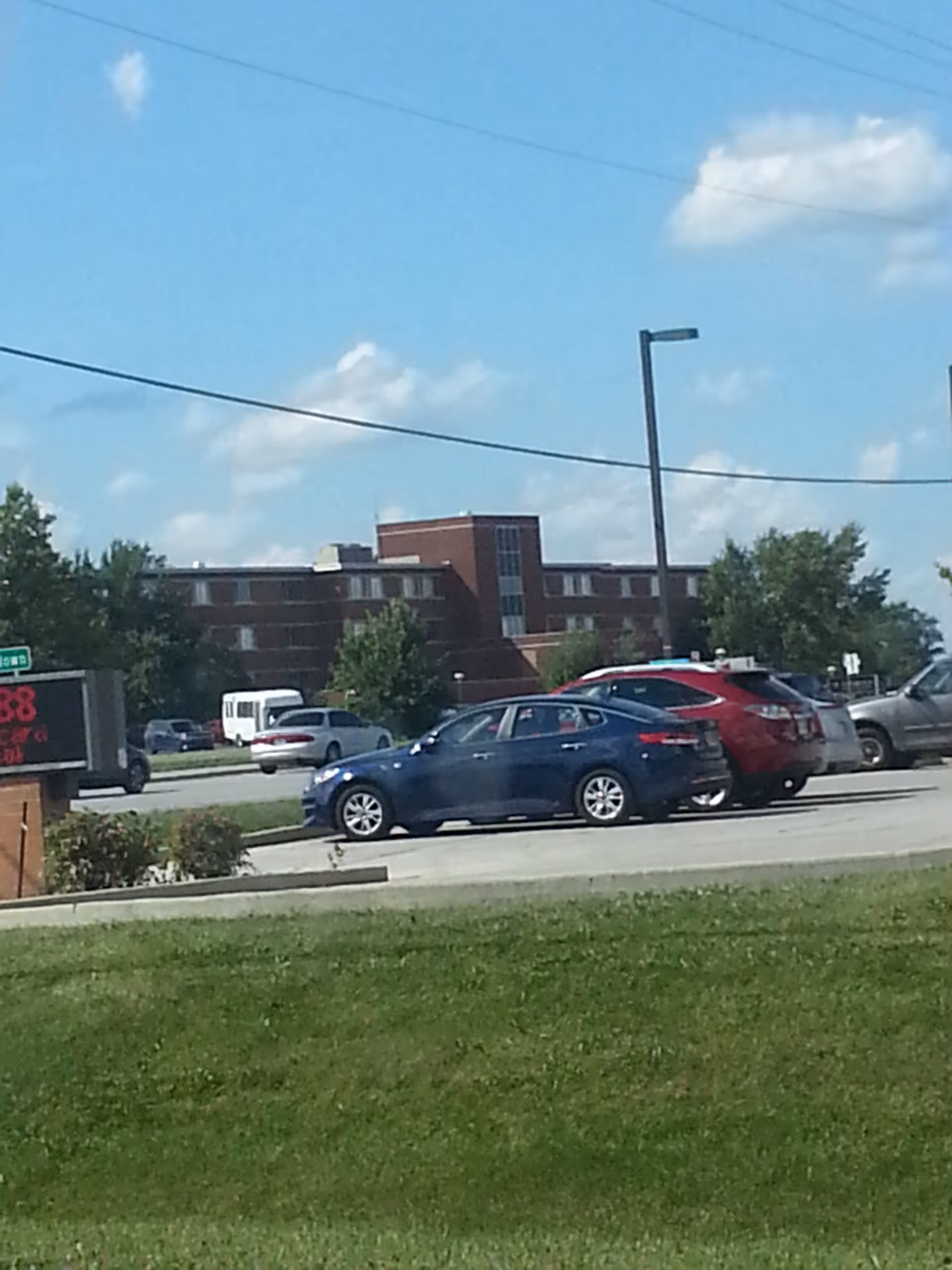 Exterior view of Byron Health Center with parked cars and a blue sky.