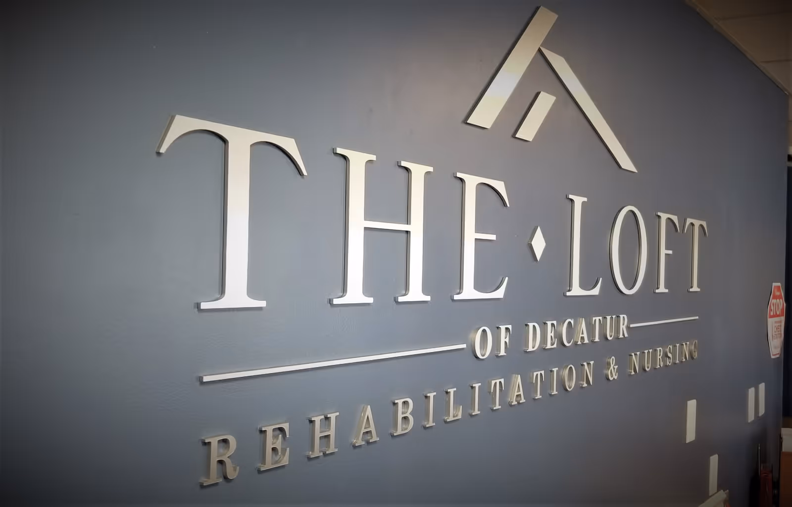 Interior wall featuring a large THE LOFT rehab and nursing sign.