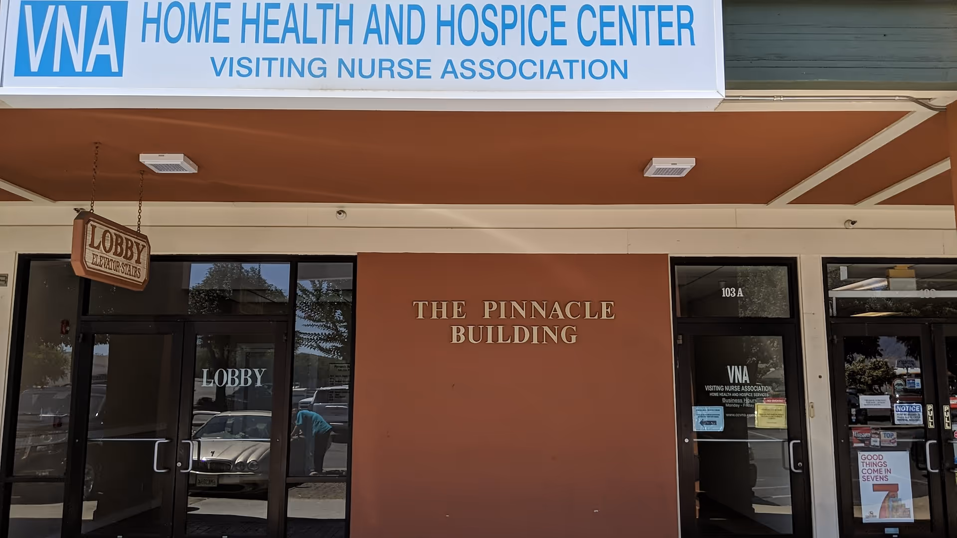 Facade of The Pinnacle Building with VNA Home Health sign and lobby doors.