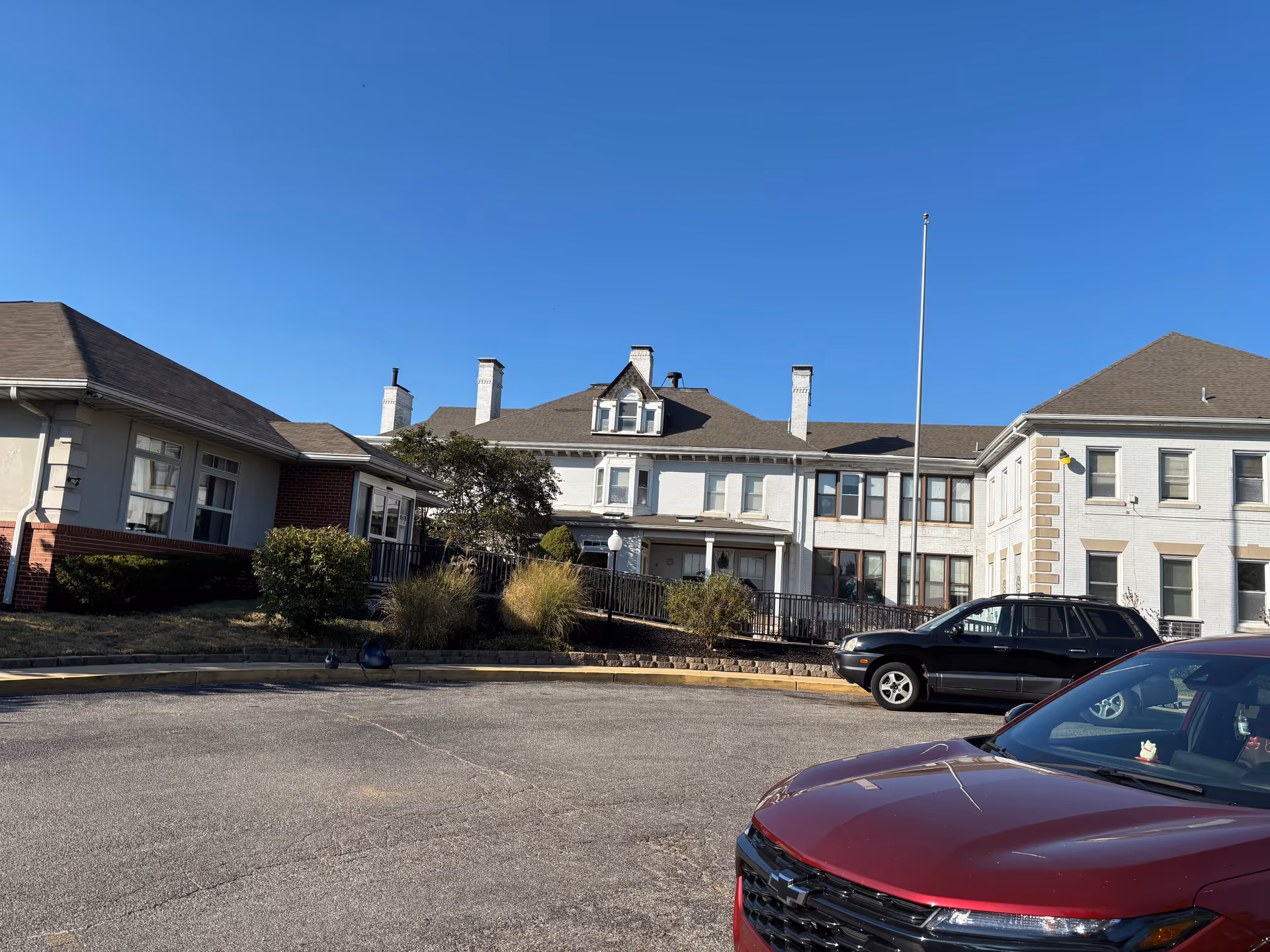 Exterior view of Avalon Garden Nursing Home building and parking lot on a clear day.