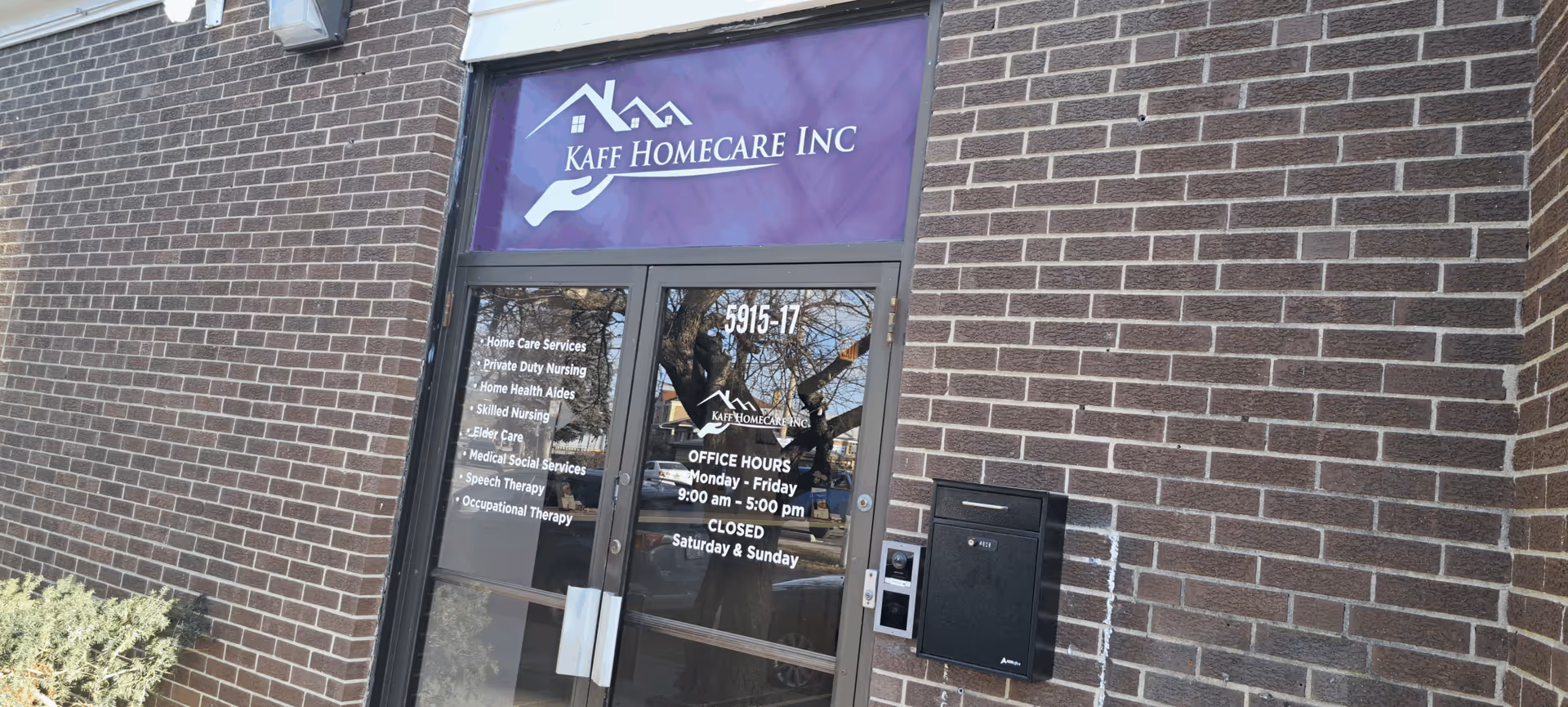Brick building entrance with KAFF Homecare Inc. sign and glass doors displaying services.