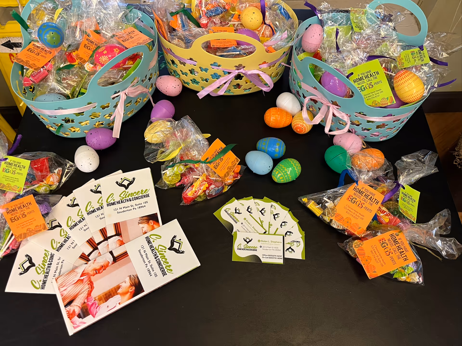 Colorful Easter baskets and brochures arranged on a dark table.