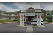 Front entrance of EverGreen Commons Rehabilitation and Nursing Center with columns and a parked vehicle.