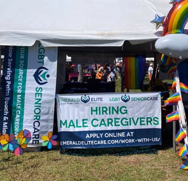 Outdoor booth with banners advertising hiring male caregivers at Emerald Senior Care.