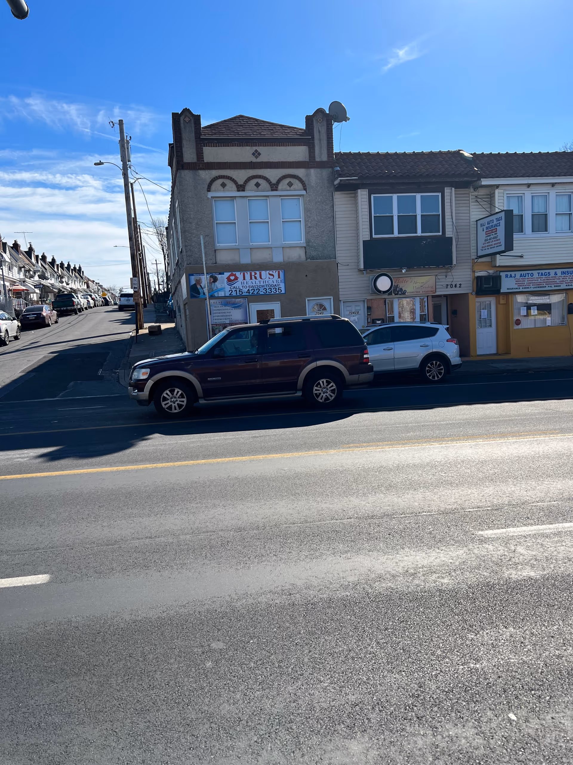 Exterior street view of a two-story Trust Healthcare building with parked cars.