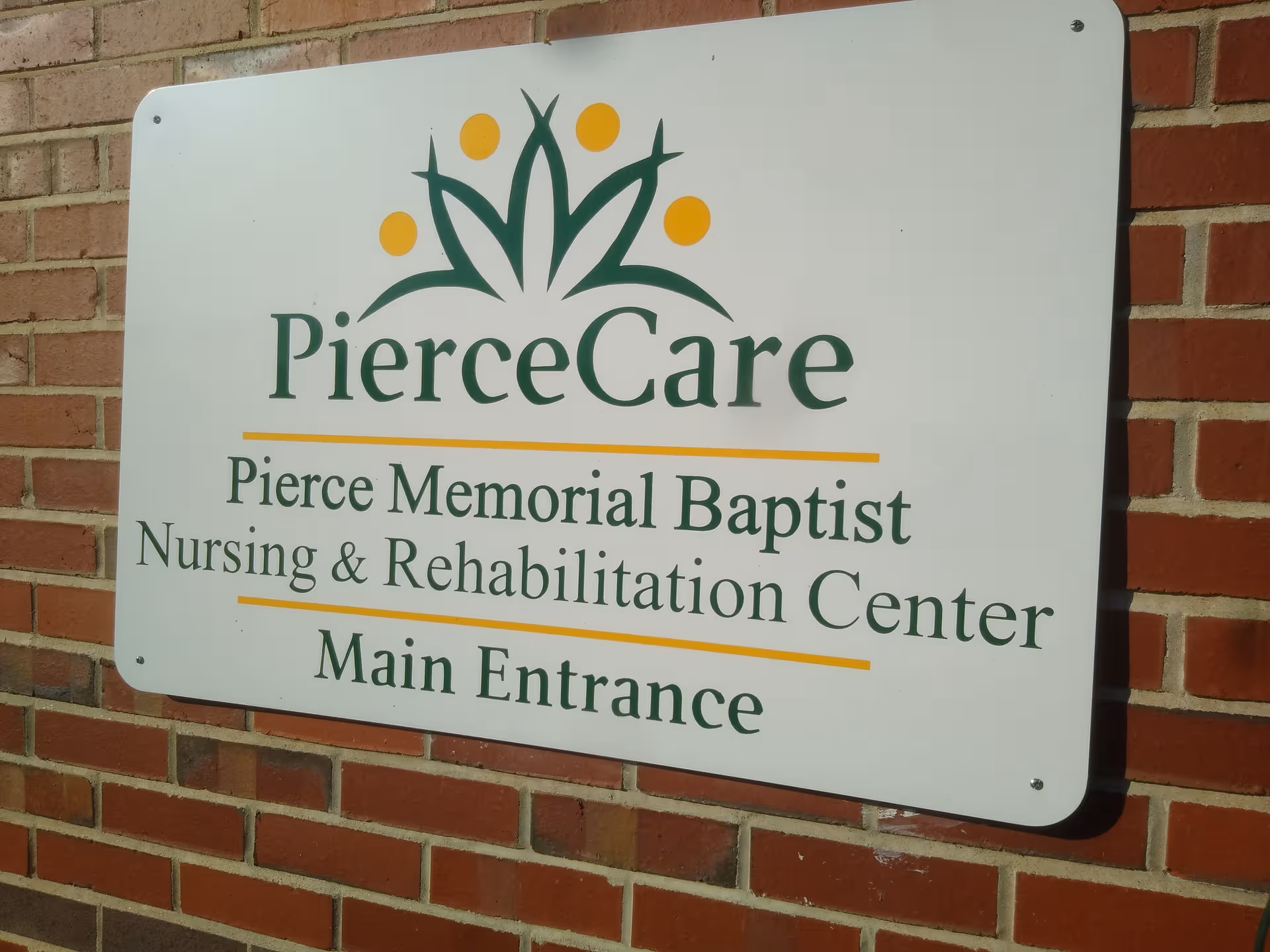 Sign on a brick exterior wall for Pierce Memorial Baptist Nursing & Rehabilitation Center.