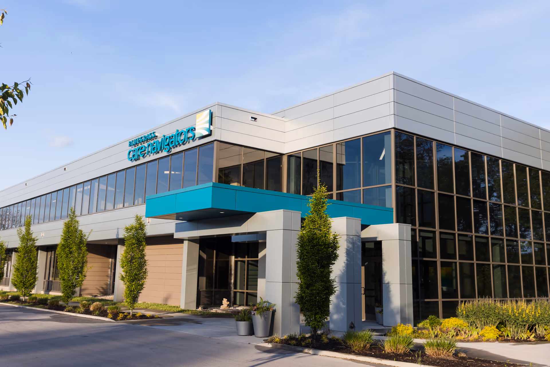 Exterior of Bluegrass Care Navigators Lexington building with large glass windows and turquoise canopy.